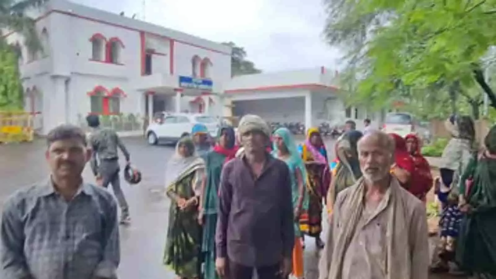 कलेक्ट्रेट कार्यालय भवन के बाहर खड़े होकर विरोध दर्ज कराते हुए ग्रामीणों का समूह।