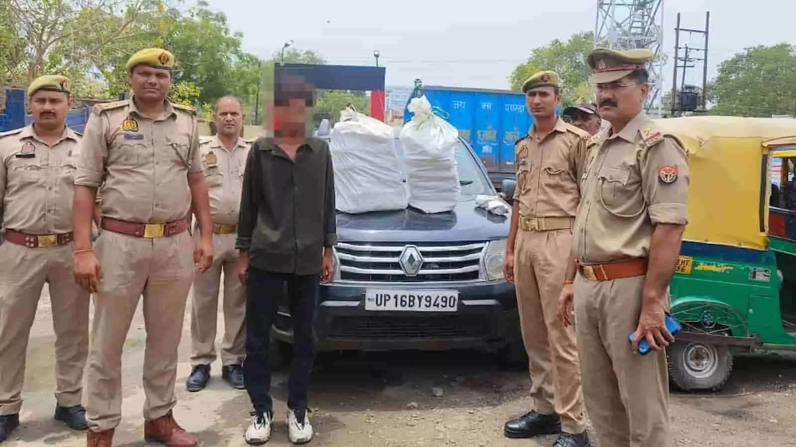 पुलिस अधिकारी एक व्यक्ति और गांजा लदी कार के साथ चंदौली में खड़े हैं। पुलिस अधिकारी एक व्यक्ति और गांजा लदी कार के साथ चंदौली में खड़े हैं।