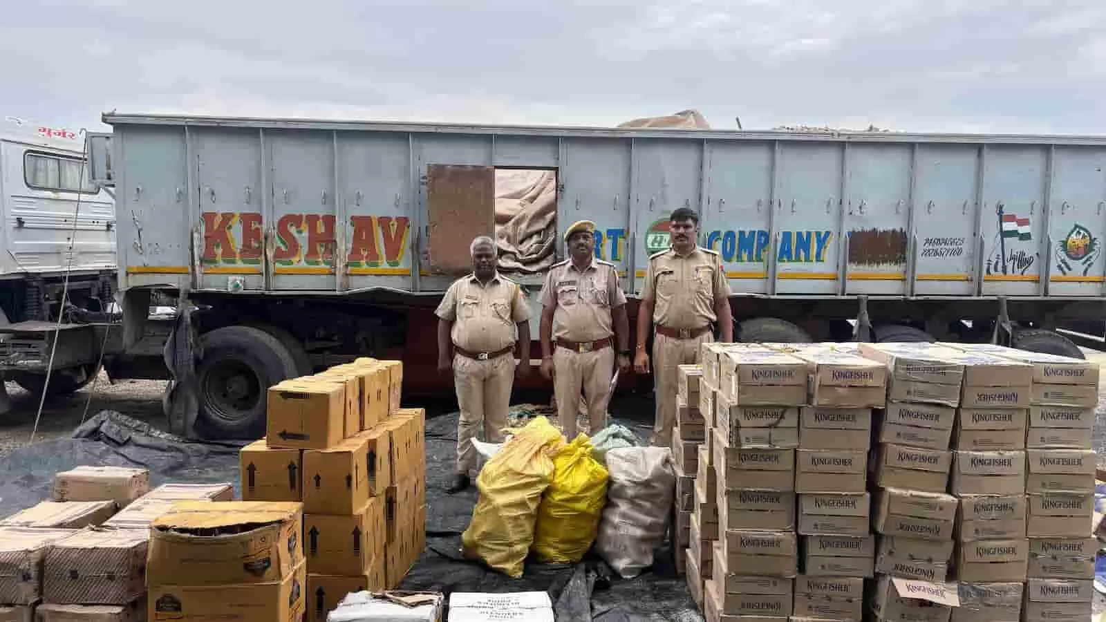 तस्वीर में पुलिसकर्मी ब्यावर के रायपुर में जब्त शराब के डिब्बों और ट्रेलर के पास खड़े हैं। तस्वीर में पुलिसकर्मी ब्यावर के रायपुर में जब्त शराब के डिब्बों और ट्रेलर के पास खड़े हैं।