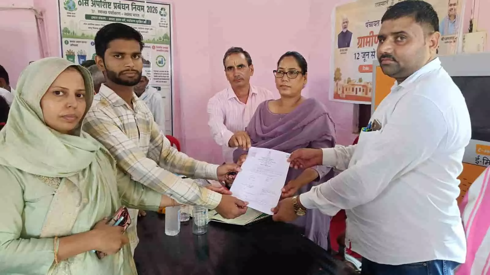 शिविर के दौरान कार्यालय में अधिकारियों द्वारा लोगों को प्रमाण पत्र सौंपने का दृश्य।