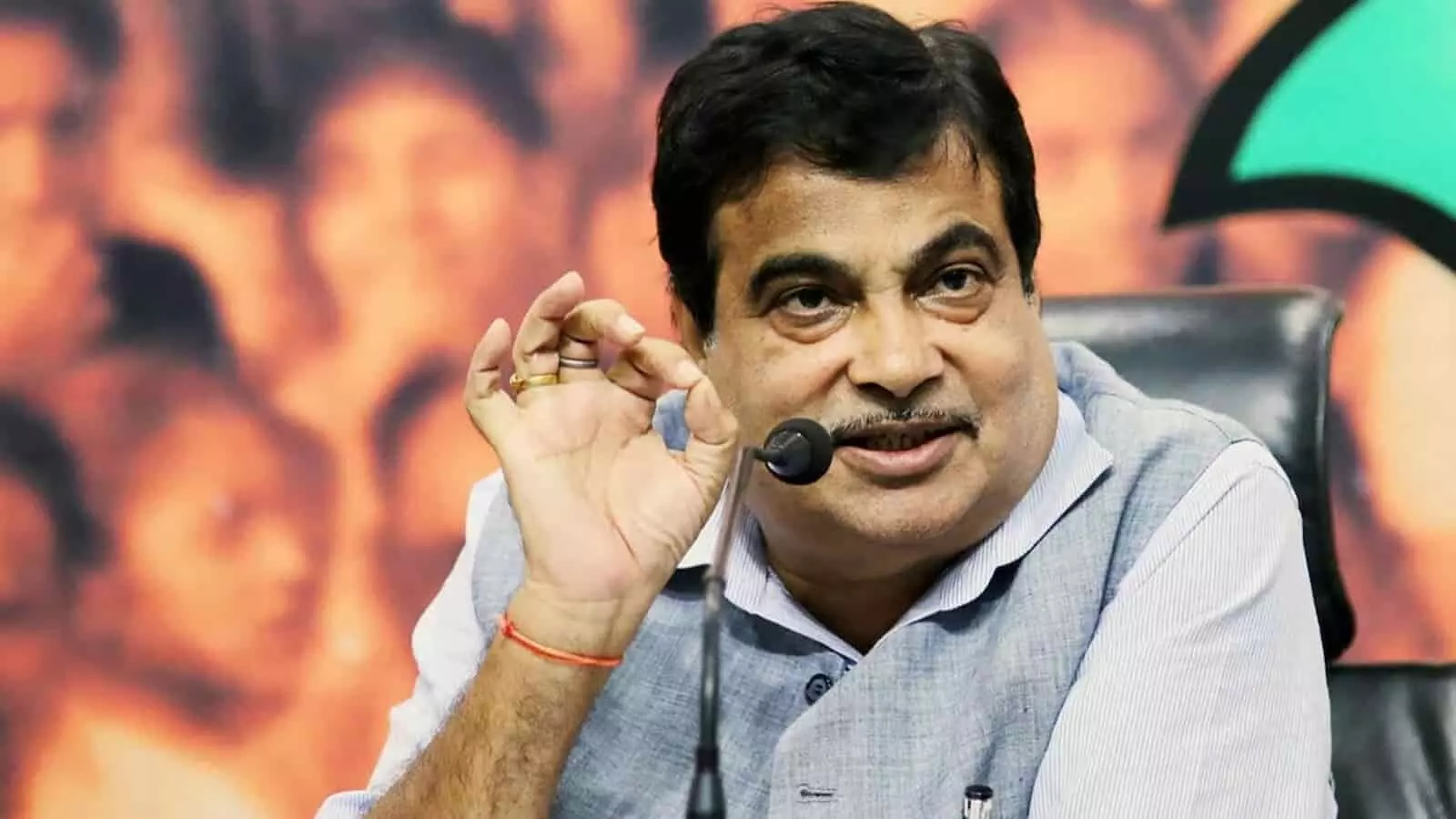 नितिन गडकरी मंच पर बैठकर बातचीत करते हुए दिखाई दे रहे हैं।