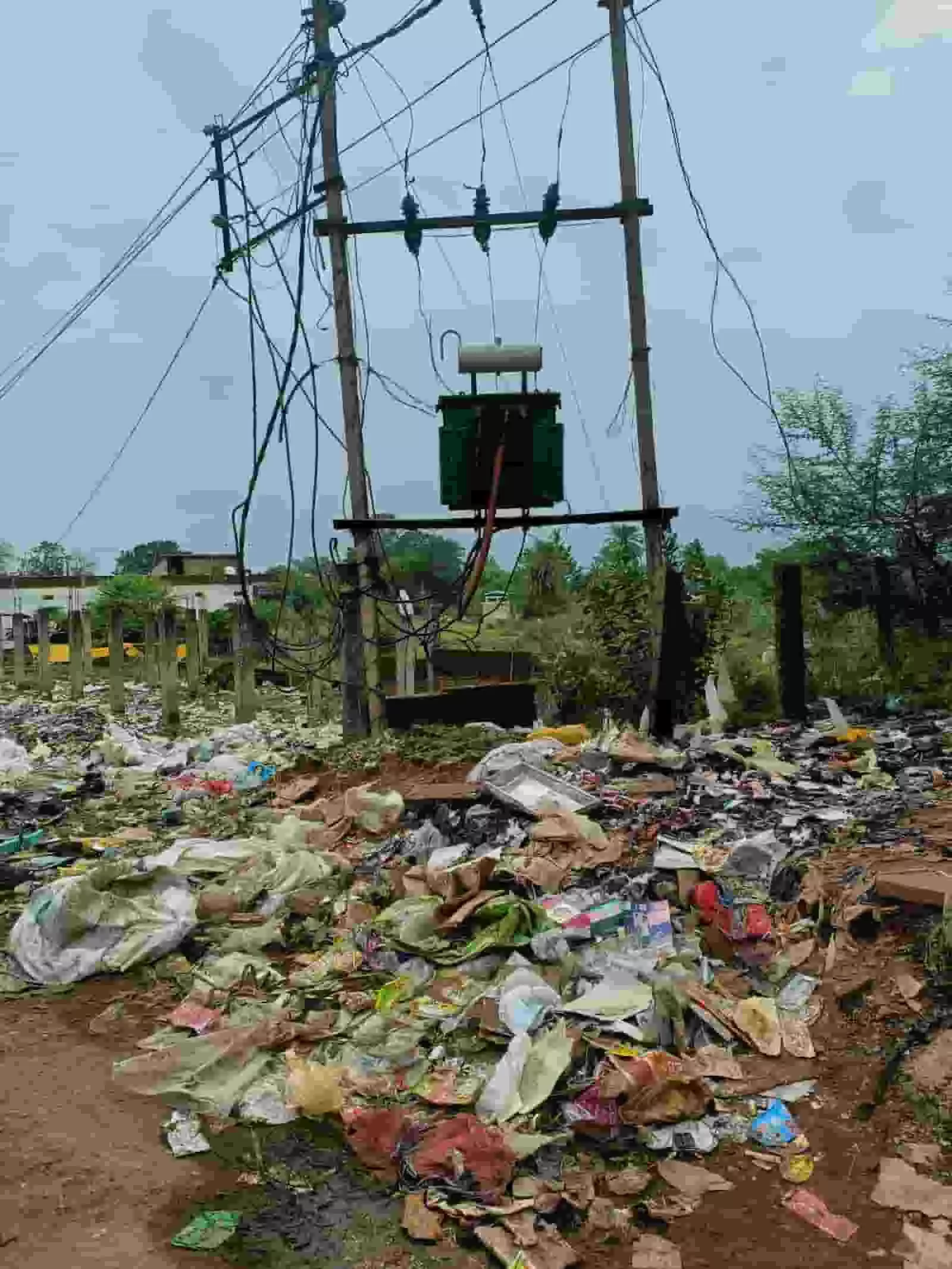 तस्वीर में कटनी के रीठी में एक विद्युत ट्रांसफॉर्मर के नीचे भारी मात्रा में बिखरा हुआ कचरा दिख रहा है।