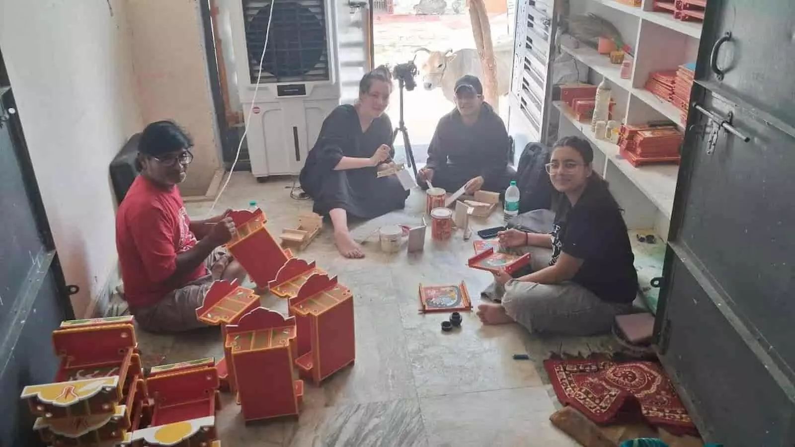 कलाकार सत्यनारायण सुथार बस्सी में अमेरिकी शोधार्थी को कावड़ बनाने की कला सिखा रहे हैं।
