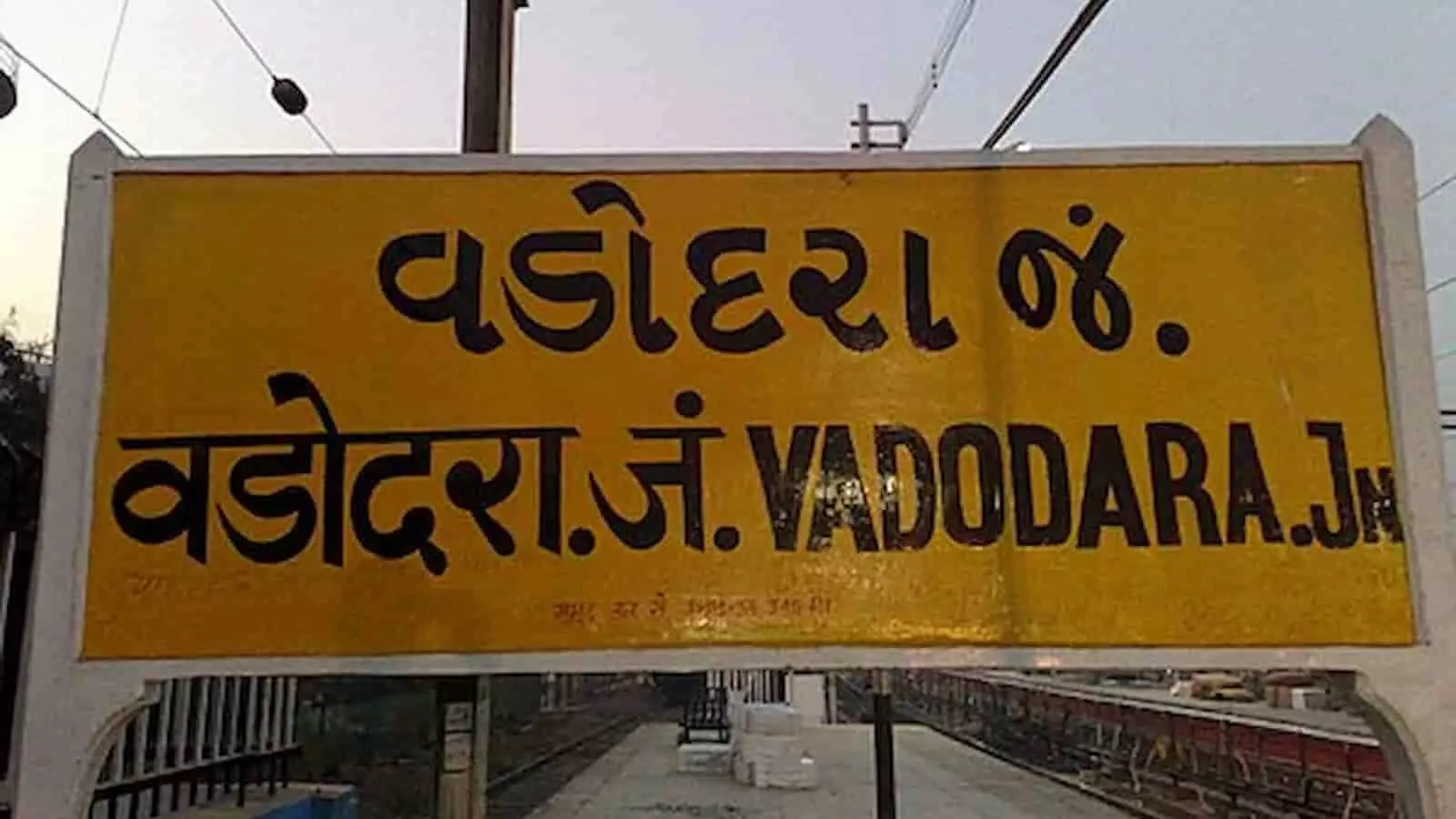 वडोदरा जंक्शन रेलवे स्टेशन का पीला साइनबोर्ड वडोदरा स्टेशन परिसर में लगा है।