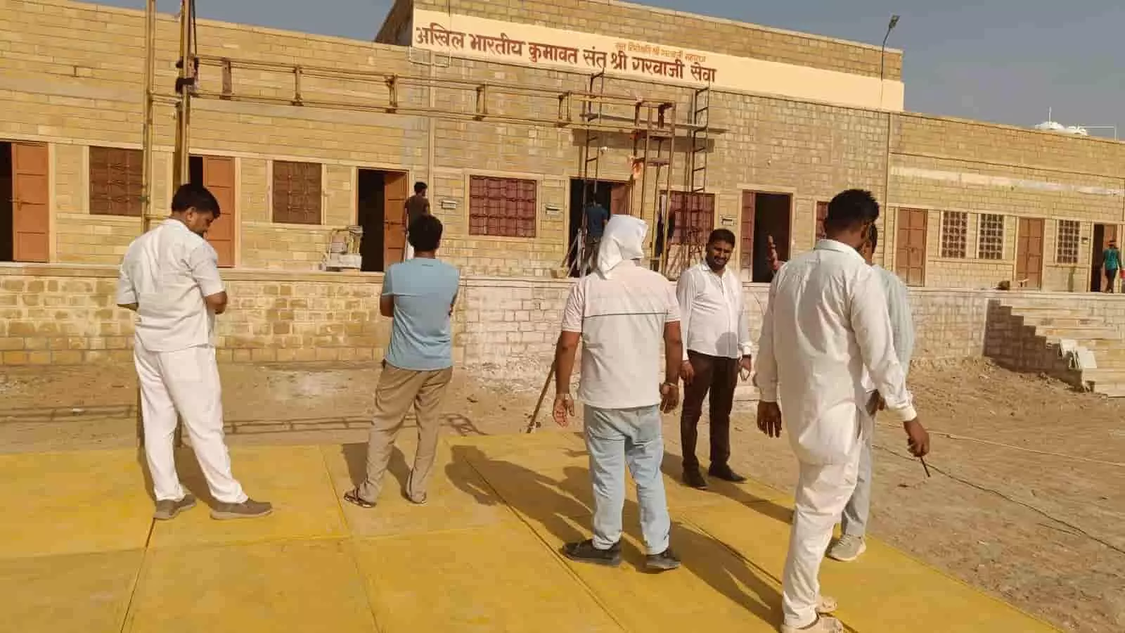 लौद्रवा के श्री गरवाजी सेवा भवन के बाहर मैदान में व्यवस्थाओं का जायजा लेते लोग।