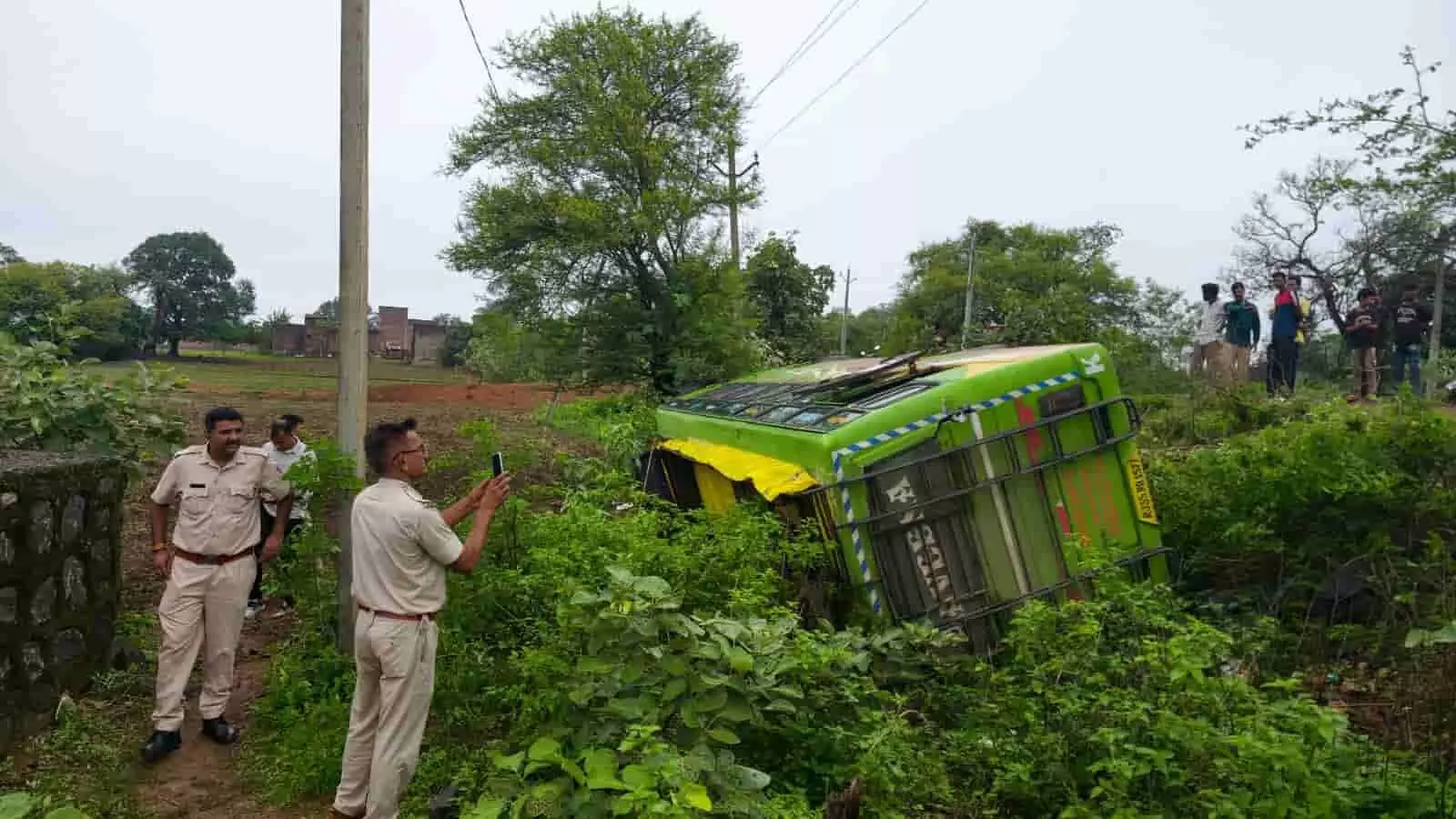 तस्वीर में झाड़ियों में पलटी बस, पुलिसकर्मी और आसपास खड़े लोग घटनास्थल पर दिखाई दे रहे हैं। तस्वीर में झाड़ियों में पलटी बस, पुलिसकर्मी और आसपास खड़े लोग घटनास्थल पर दिखाई दे रहे हैं।
