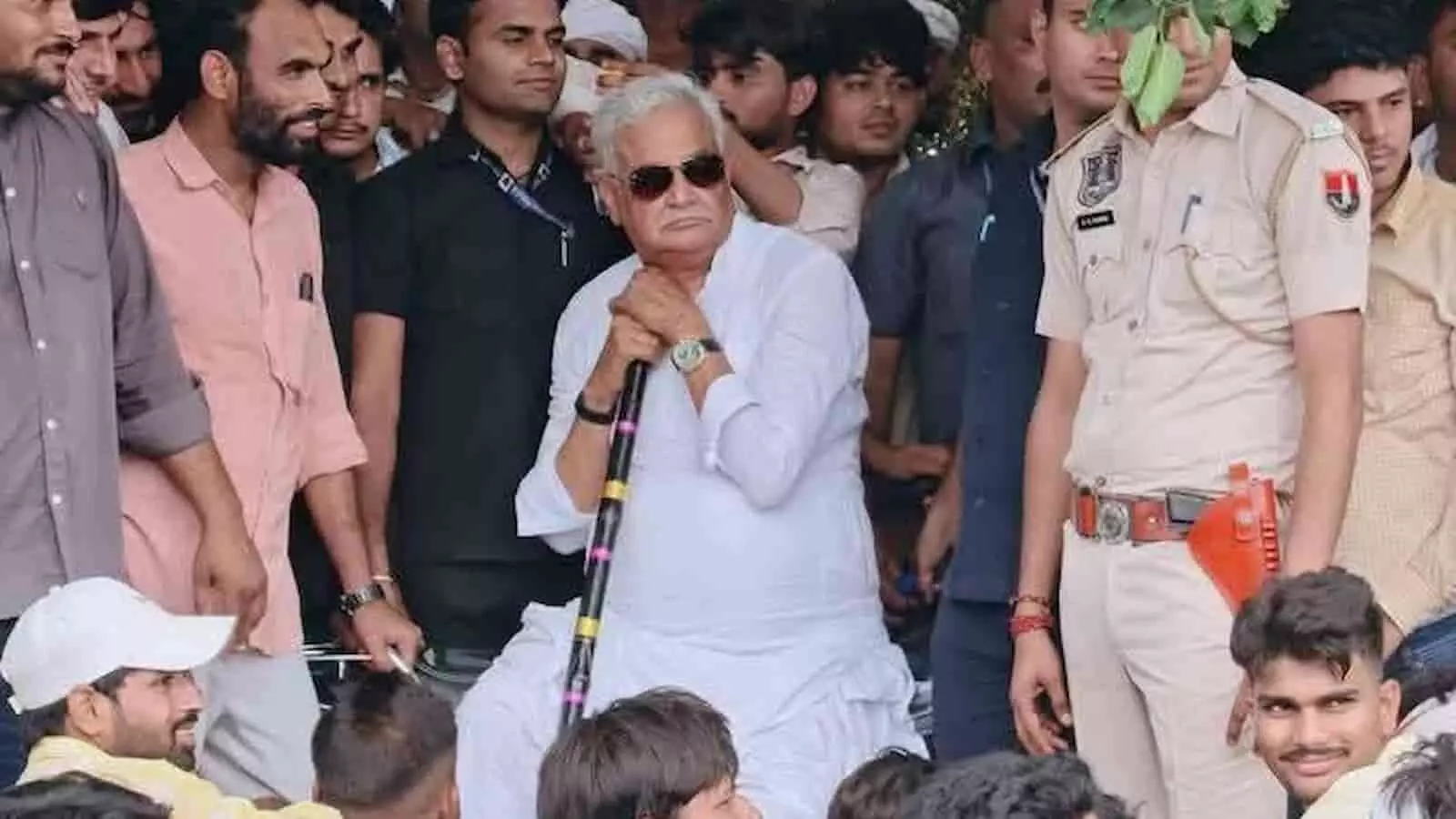 तस्वीर में भीड़ के बीच लाठी लेकर बैठे राजस्थान के कृषि मंत्री डॉ. किरोड़ी लाल मीणा दिख रहे हैं।