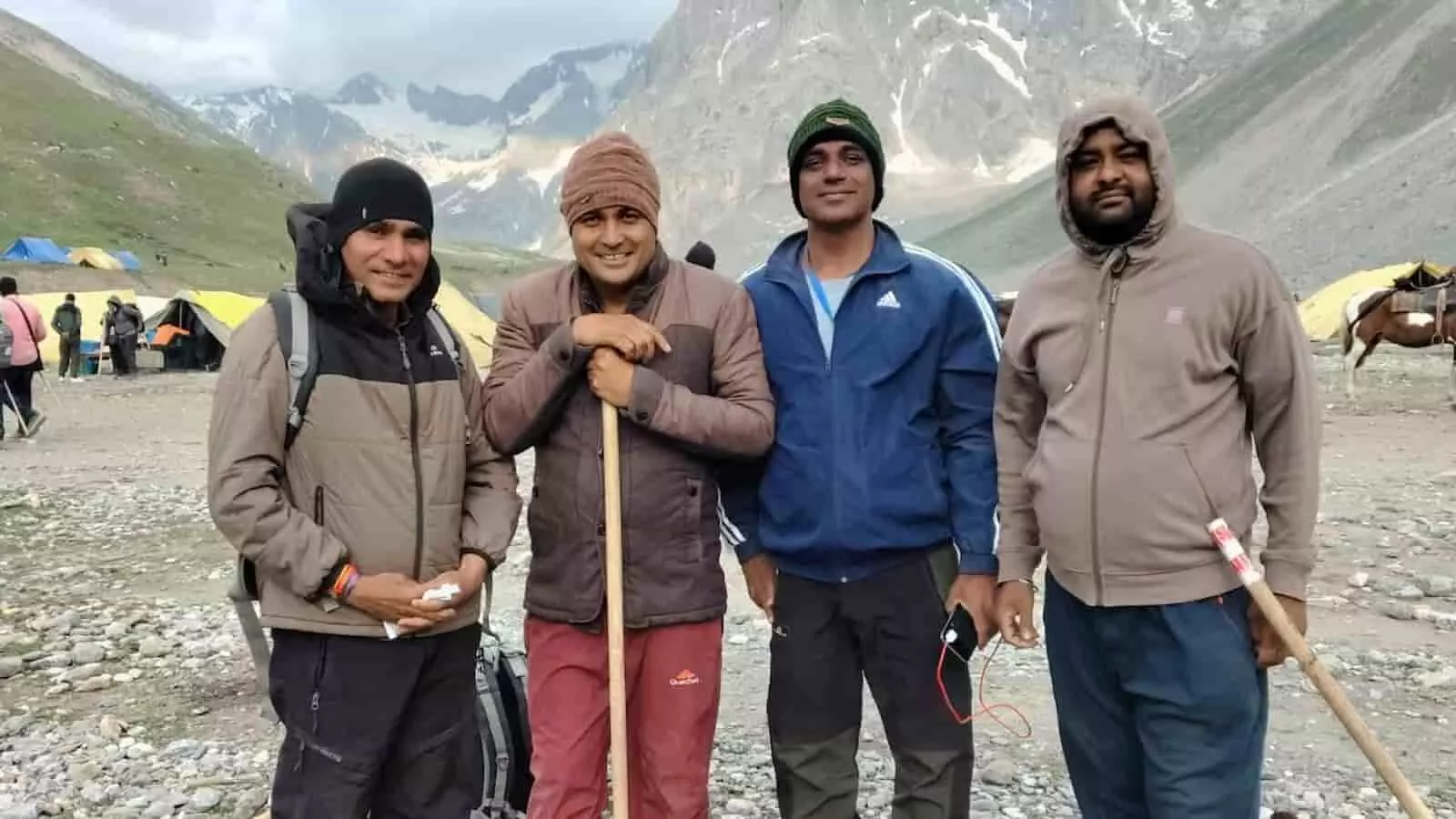 पहाड़ी पृष्ठभूमि में चार श्रद्धालु यात्रा के दौरान खड़े हुए दिखाई दे रहे हैं। पहाड़ी पृष्ठभूमि में चार श्रद्धालु यात्रा के दौरान खड़े हुए दिखाई दे रहे हैं।