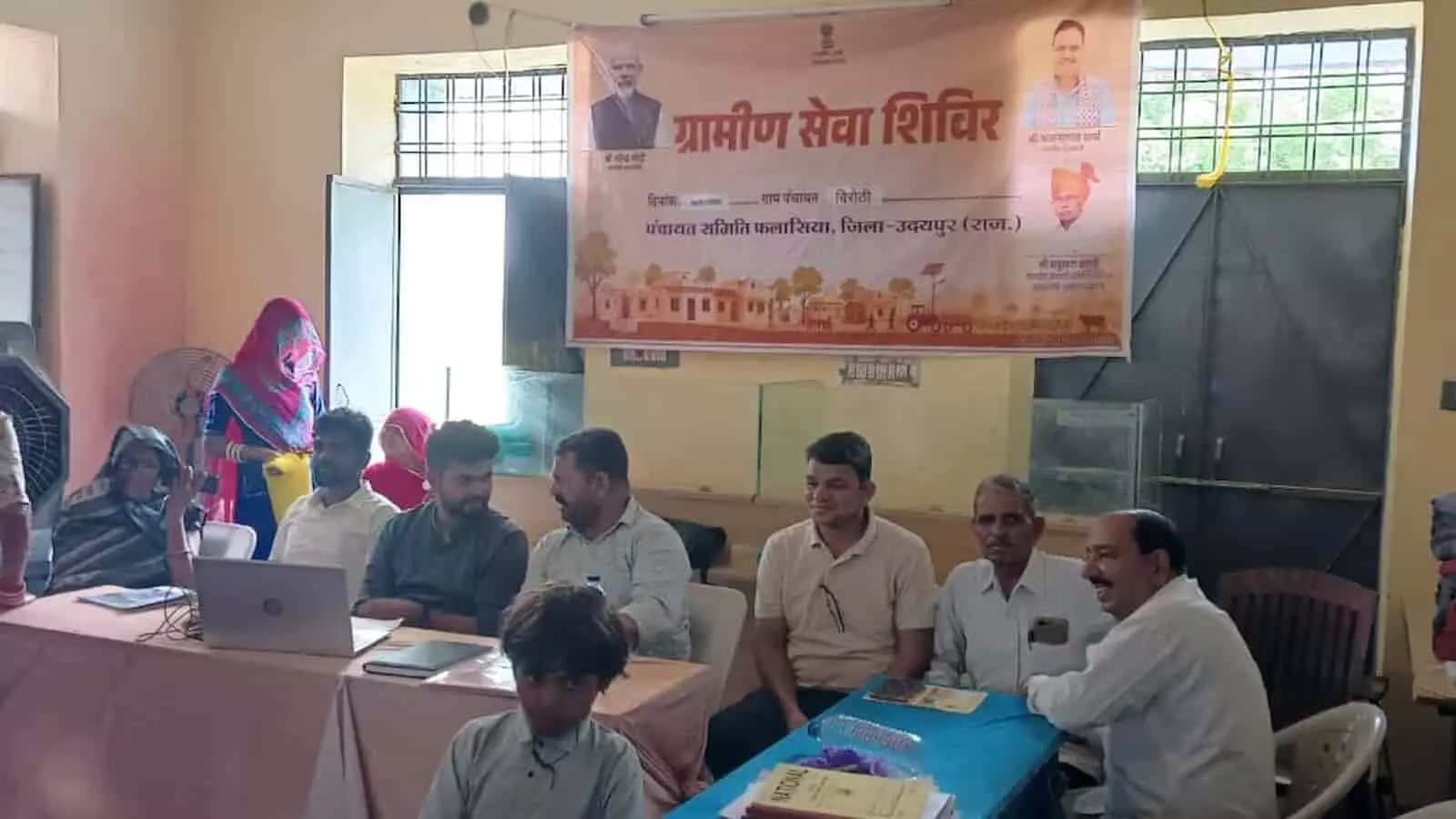 तस्वीर में ग्रामीण सेवा शिविर के बैनर तले बैठे अधिकारी और स्थानीय लोग जनसुनवाई करते हुए। तस्वीर में ग्रामीण सेवा शिविर के बैनर तले बैठे अधिकारी और स्थानीय लोग जनसुनवाई करते हुए।