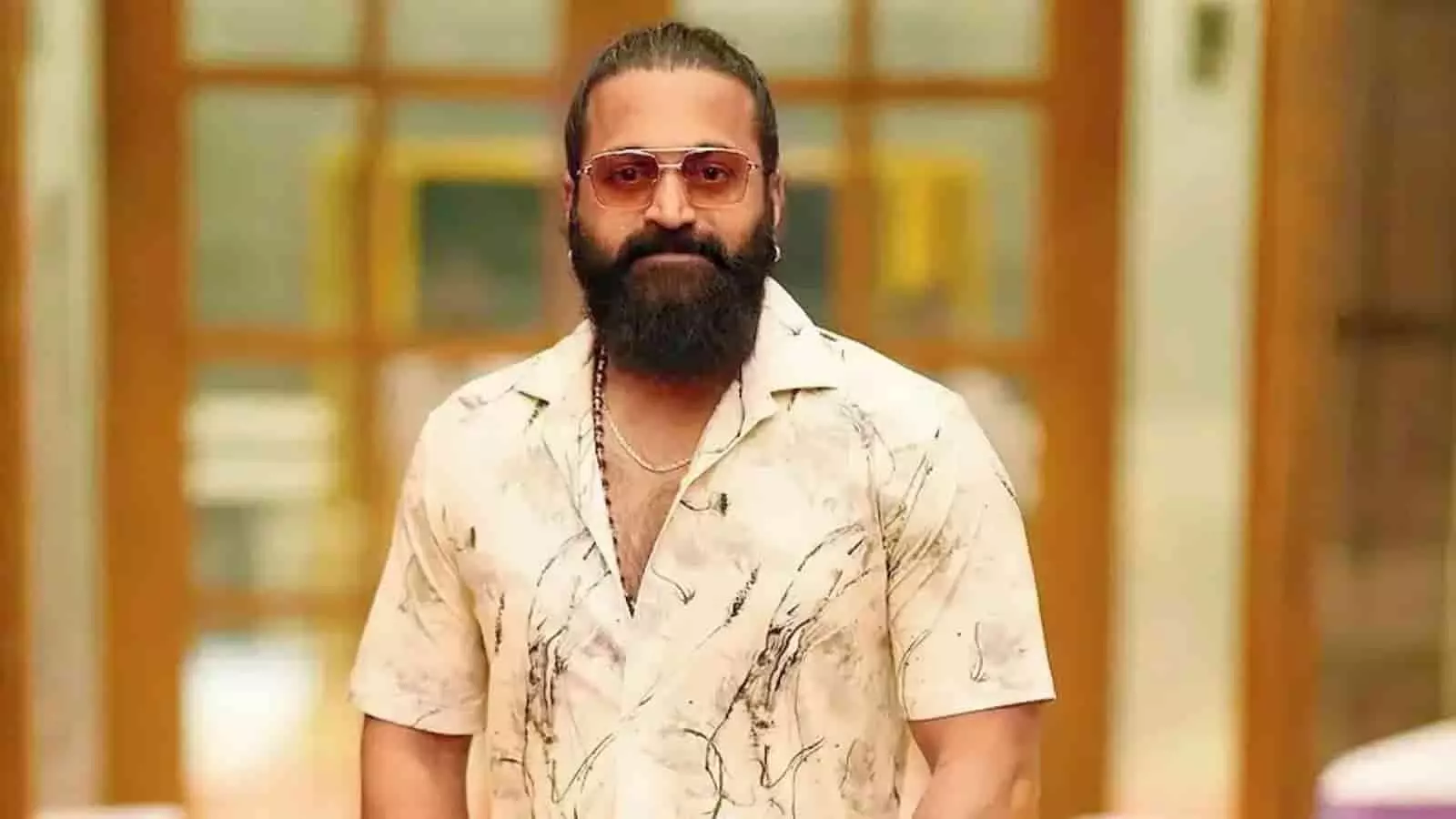 तस्वीर में अभिनेता ऋषभ शेट्टी सफेद शर्ट और चश्मा पहने हुए खड़े हैं। तस्वीर में अभिनेता ऋषभ शेट्टी सफेद शर्ट और चश्मा पहने हुए खड़े हैं।