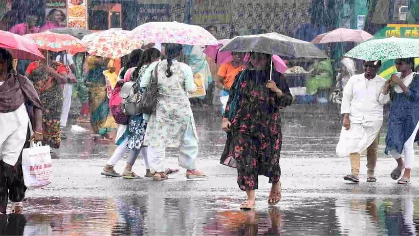 दक्षिण भारत में बारिश के दौरान छाता लेकर सड़क पर चलते हुए लोग।