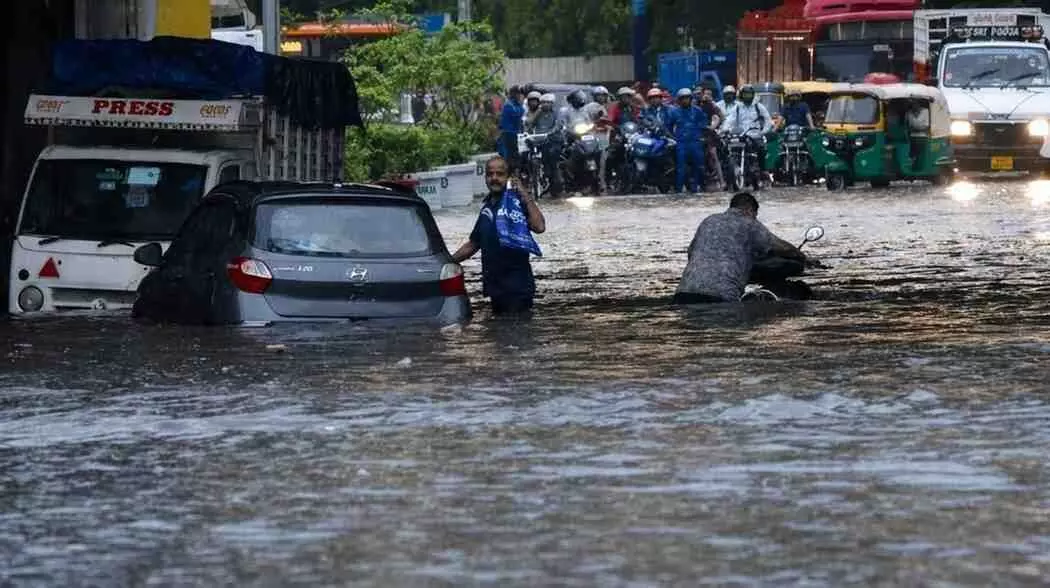 लाजपत नगर की सड़क पर भरा पानी और वहां से गुजरते वाहन व लोग।