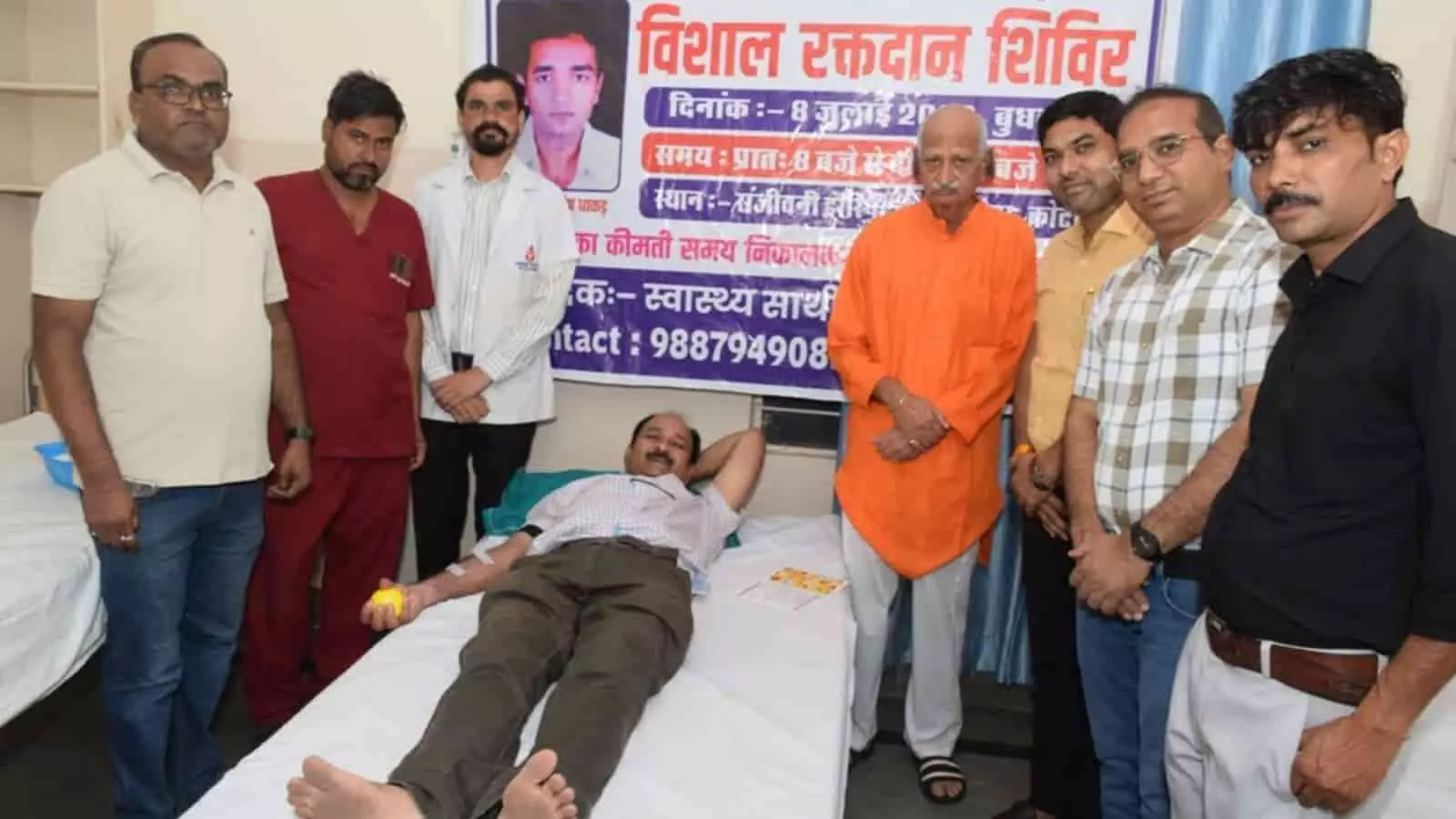 तस्वीर में रक्तदाता, डॉ. संजय धाकड़ और अन्य लोग संजीवनी हॉस्पिटल कोटा में रक्तदान शिविर के दौरान दिखाई दे रहे हैं।