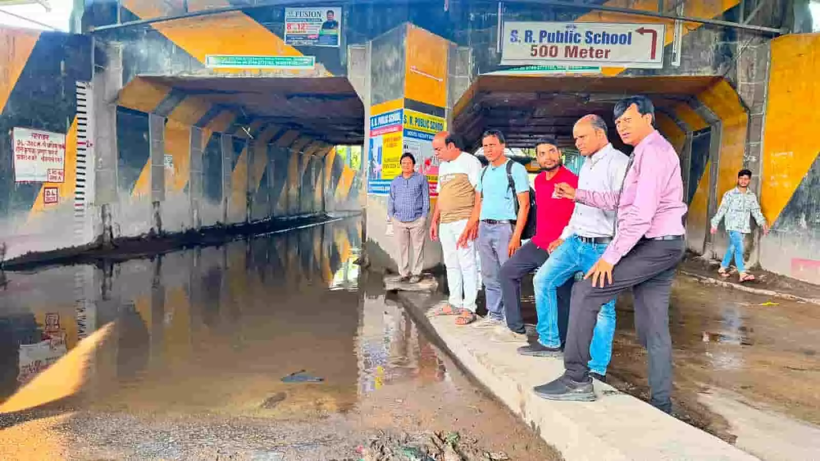 तस्वीर में कोटा के डकनिया रेलवे अंडरपास में जलभराव के पास खड़े लोग निरीक्षण करते हुए।