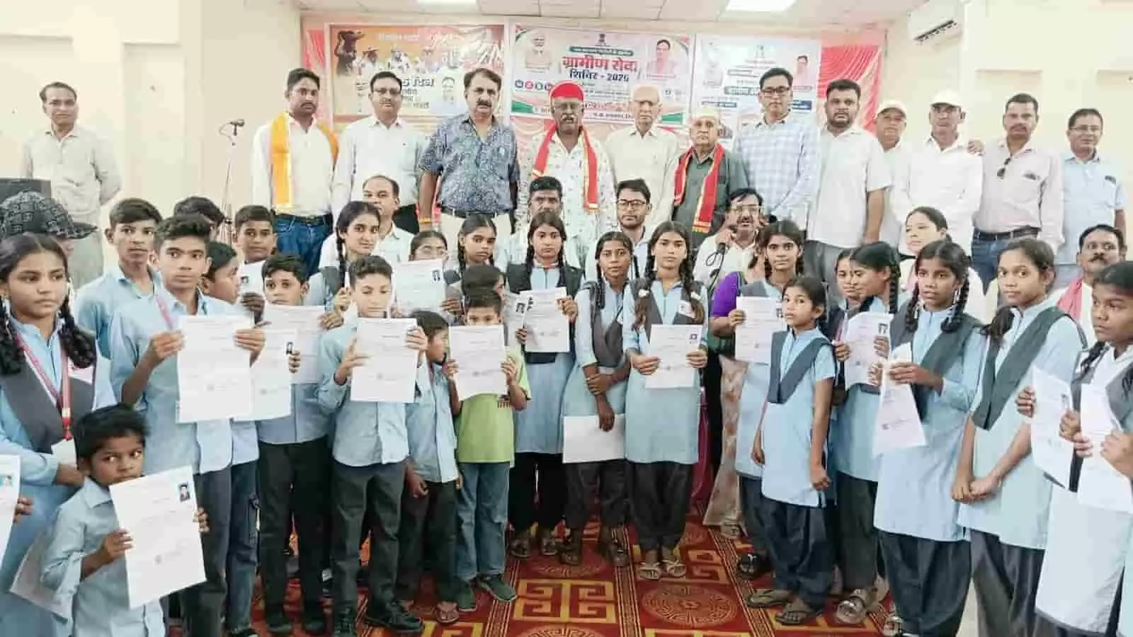 ग्रामीण विकास शिविर में प्रमाण पत्र लिए स्कूली बच्चे और जन प्रतिनिधि उपस्थित हैं। ग्रामीण विकास शिविर में प्रमाण पत्र लिए स्कूली बच्चे और जन प्रतिनिधि उपस्थित हैं।