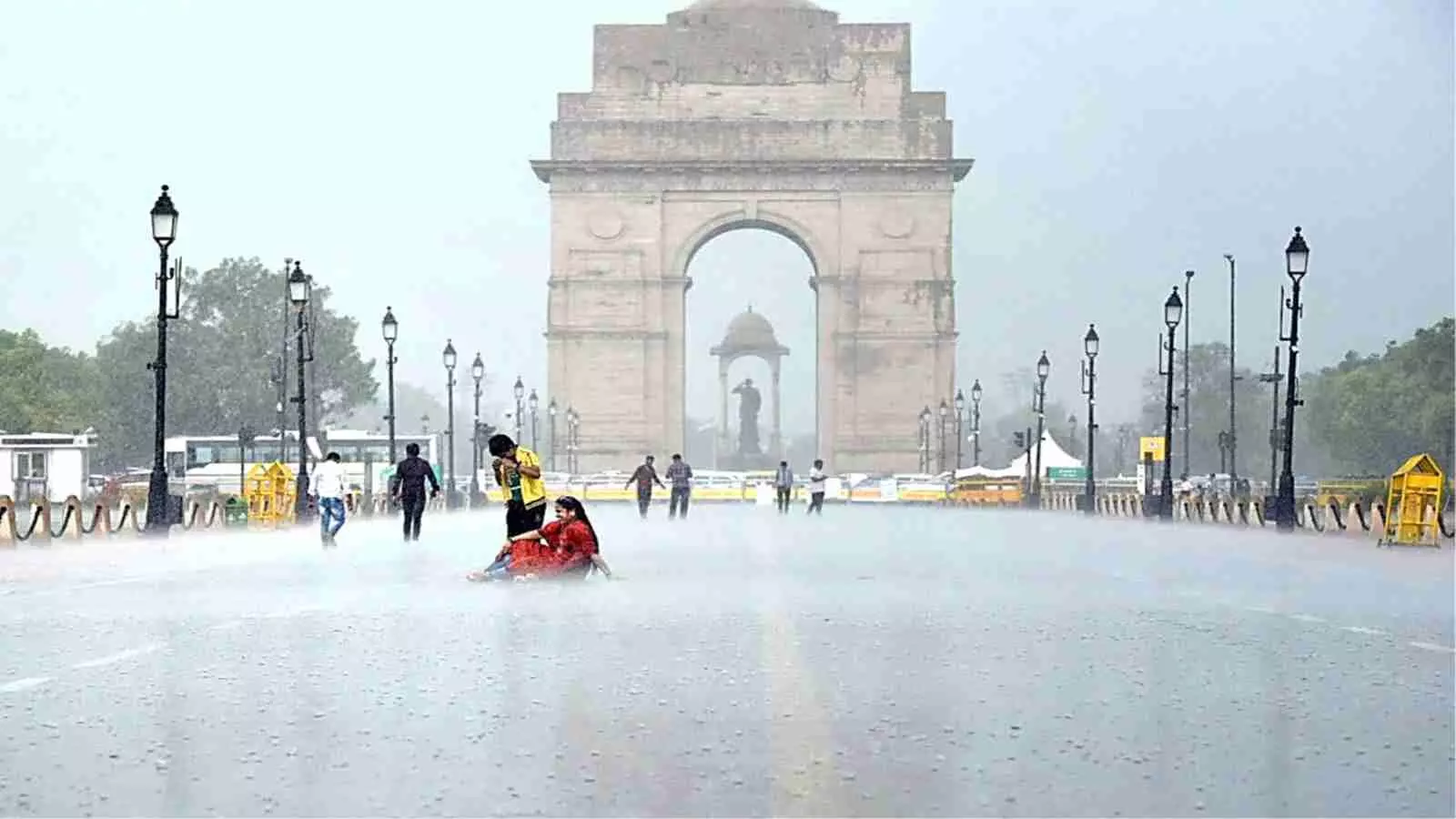 दिल्ली में इंडिया गेट के पास बारिश होने से सड़कों पर पानी जमा हुआ है।