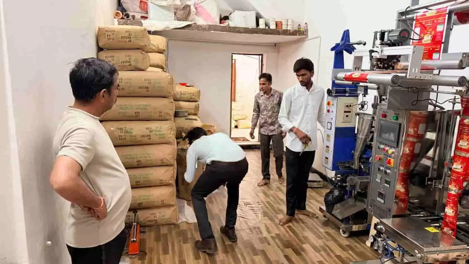 गोदाम में रखी बोरियों और पैकिंग मशीन का निरीक्षण करते खाद्य सुरक्षा अधिकारी। गोदाम में रखी बोरियों और पैकिंग मशीन का निरीक्षण करते खाद्य सुरक्षा अधिकारी।