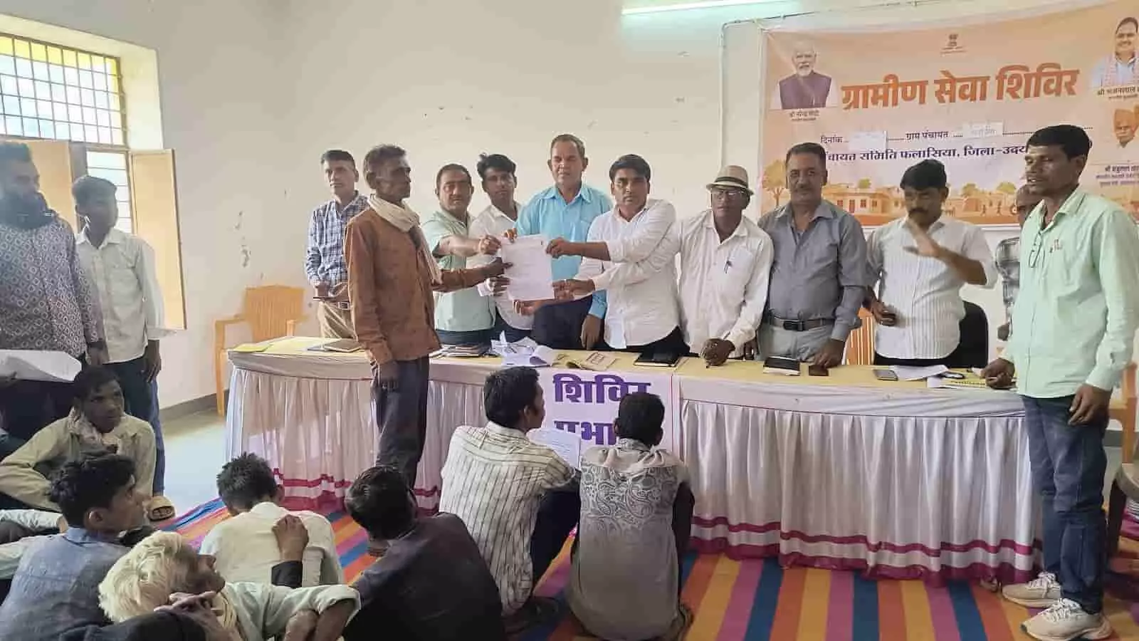 शिविर में अधिकारी लाभार्थी को पेंशन पीपीओ का दस्तावेज सौंपते हुए दिख रहे हैं। शिविर में अधिकारी लाभार्थी को पेंशन पीपीओ का दस्तावेज सौंपते हुए दिख रहे हैं।