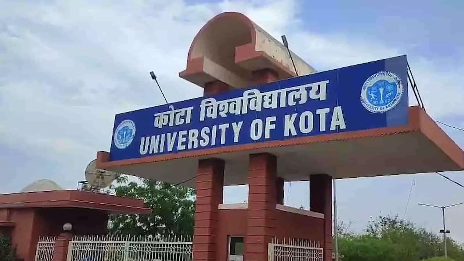 कोटा विश्वविद्यालय का मुख्य प्रवेश द्वार नीले रंग के बोर्ड के साथ स्थित है। कोटा विश्वविद्यालय का मुख्य प्रवेश द्वार नीले रंग के बोर्ड के साथ स्थित है।