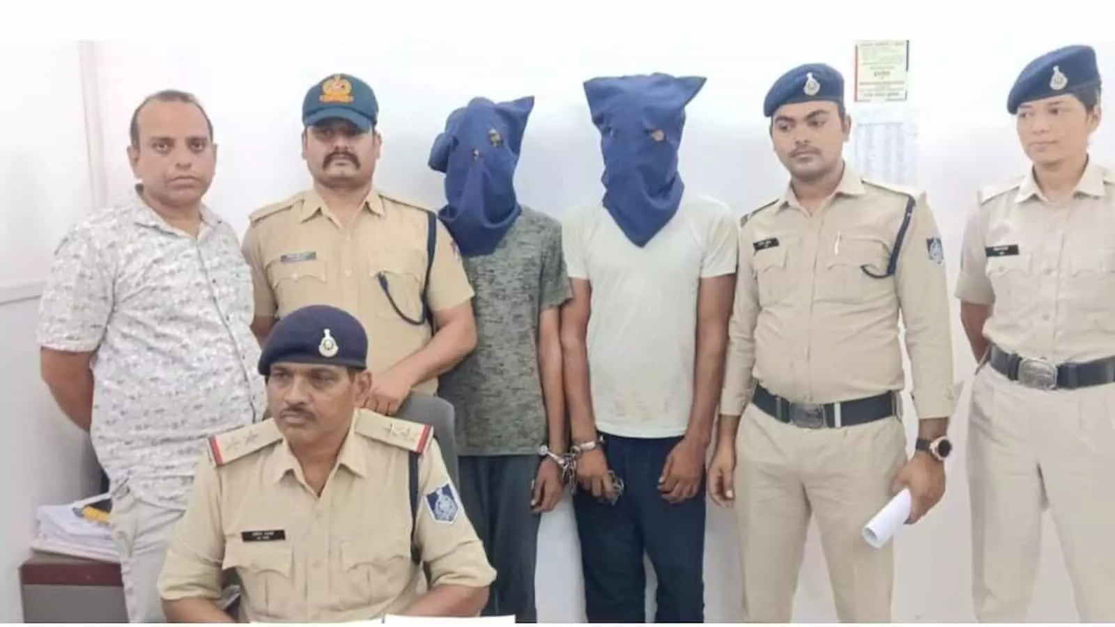 कटनी जीआरपी थाने में पुलिसकर्मियों की कस्टडी में खड़े दो नकाबपोश आरोपी।
