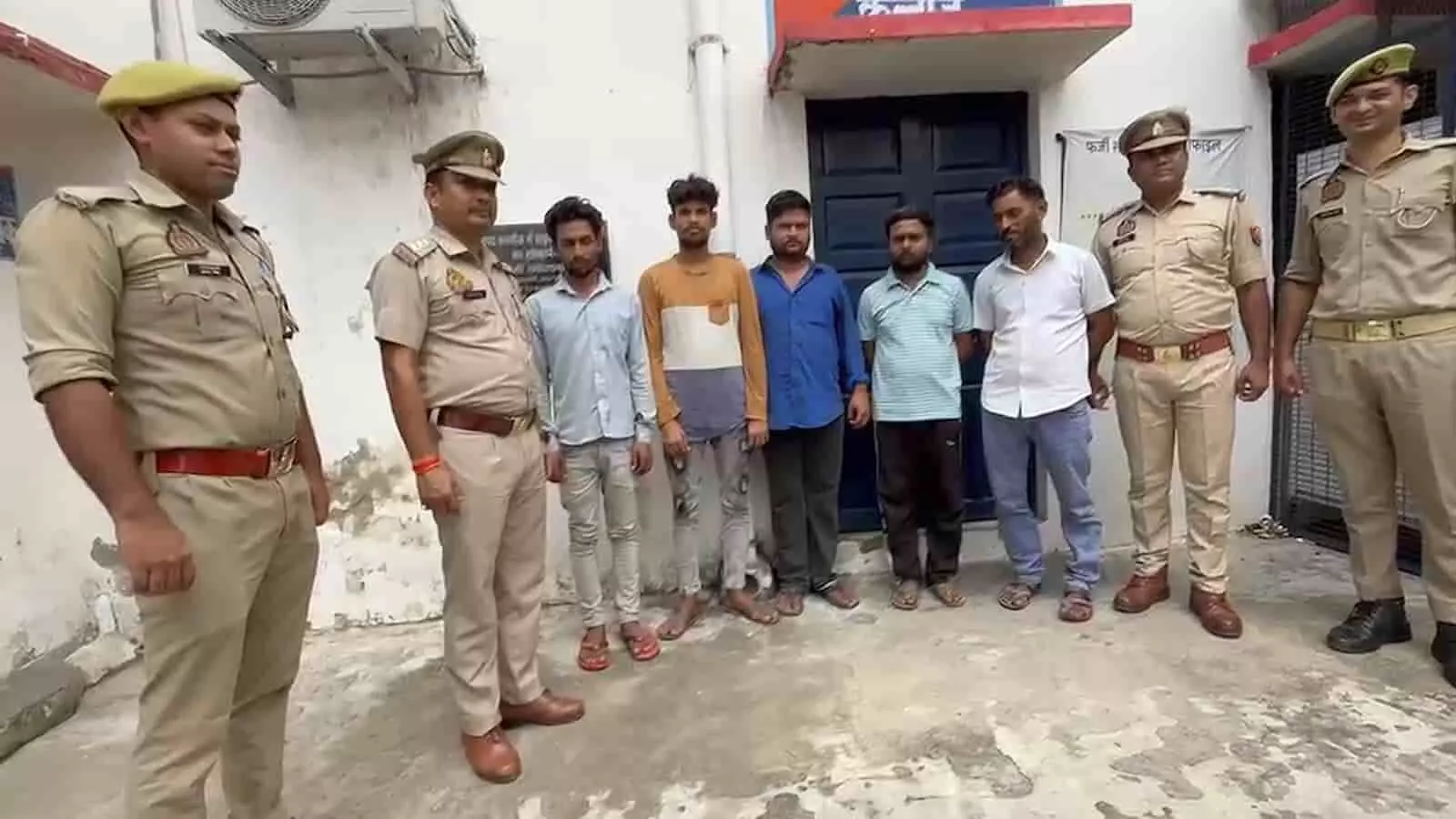 तस्वीर में कन्नौज पुलिस थाने के बाहर पुलिसकर्मी और गिरफ्तार किए गए पांच आरोपी खड़े दिख रहे हैं। तस्वीर में कन्नौज पुलिस थाने के बाहर पुलिसकर्मी और गिरफ्तार किए गए पांच आरोपी खड़े दिख रहे हैं।