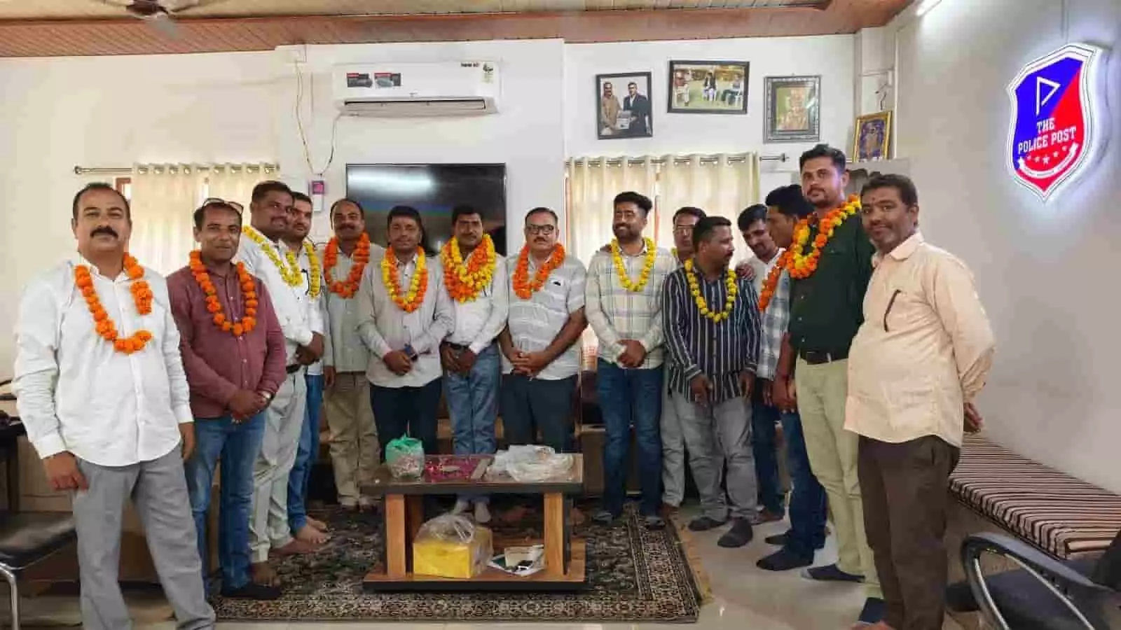 एक इनडोर कमरे में फूलों की माला पहने कई पुरुष सदस्य एक साथ खड़े हैं। एक इनडोर कमरे में फूलों की माला पहने कई पुरुष सदस्य एक साथ खड़े हैं।