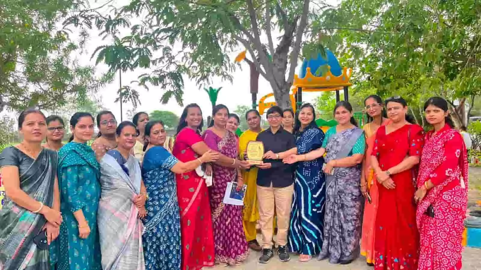 तस्वीर में स्कूल परिसर के खुले मैदान में कई महिलाएं एकत्र होकर एक ट्रेनर को मोमेंटो देती हुईं। तस्वीर में स्कूल परिसर के खुले मैदान में कई महिलाएं एकत्र होकर एक ट्रेनर को मोमेंटो देती हुईं।