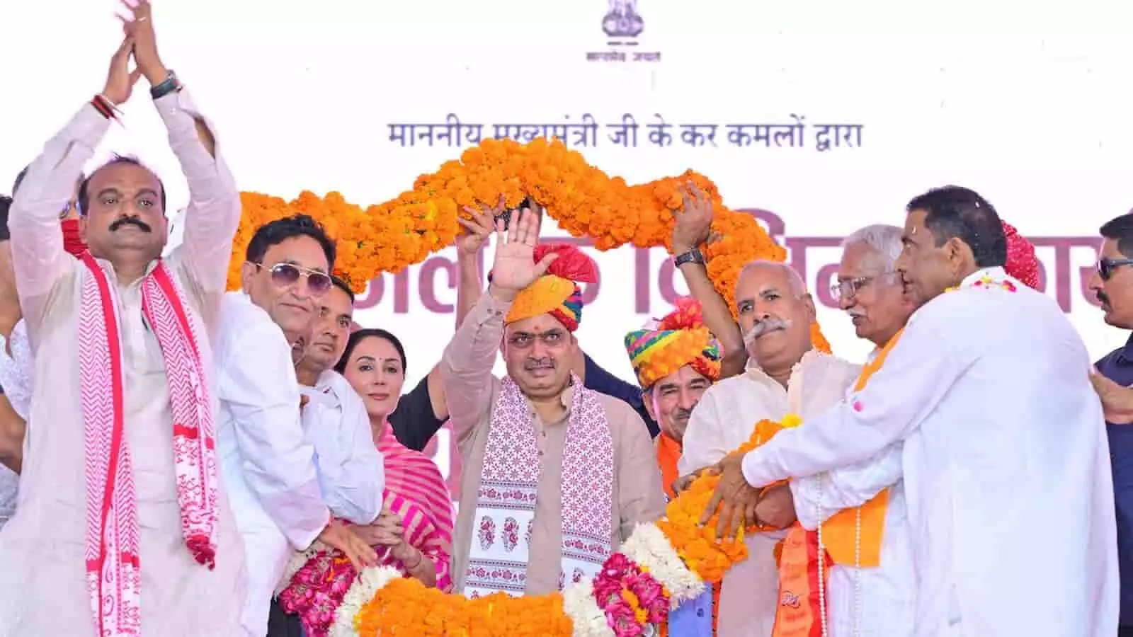 बड़ी फूलों की माला पहने मुख्यमंत्री भजनलाल शर्मा केकड़ी में कार्यक्रम के दौरान अभिवादन करते हुए। बड़ी फूलों की माला पहने मुख्यमंत्री भजनलाल शर्मा केकड़ी में कार्यक्रम के दौरान अभिवादन करते हुए।