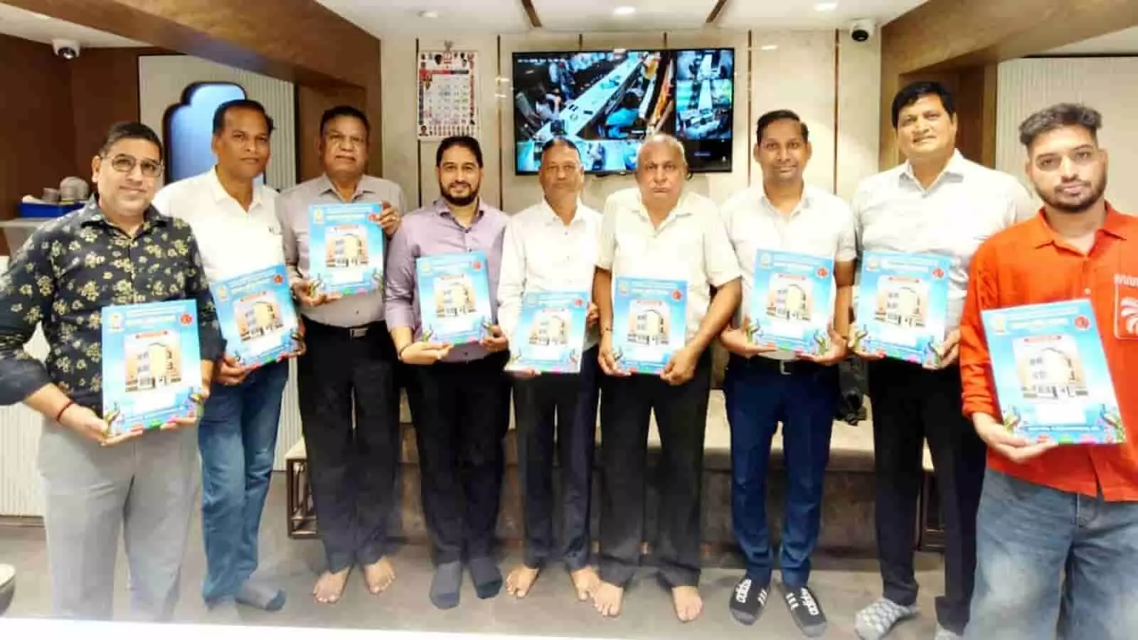 तस्वीर में ओसवाल जैन समाज के पदाधिकारी हाथ में आमंत्रण पत्रिका लेकर खड़े हैं।
