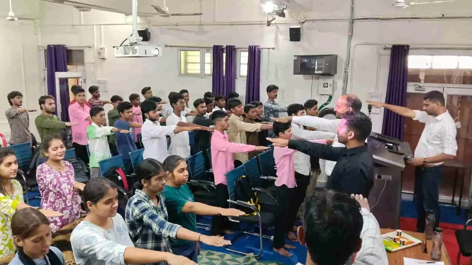 तस्वीर में कॉलेज के हॉल के अंदर छात्र और शिक्षक नशा मुक्ति की शपथ लेते हुए दिख रहे हैं।