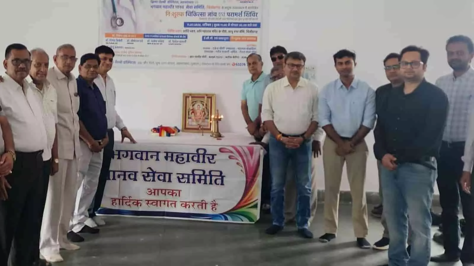 चिकित्सा शिविर के उद्घाटन समारोह में भगवान महावीर के चित्र के पास खड़े समिति पदाधिकारी और चिकित्सक। चिकित्सा शिविर के उद्घाटन समारोह में भगवान महावीर के चित्र के पास खड़े समिति पदाधिकारी और चिकित्सक।