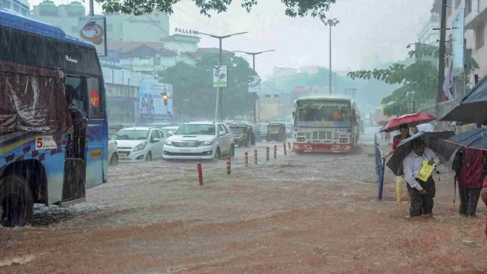 बारिश के दौरान दक्षिण भारत की सड़कों पर छाता लेकर चलते हुए लोग।