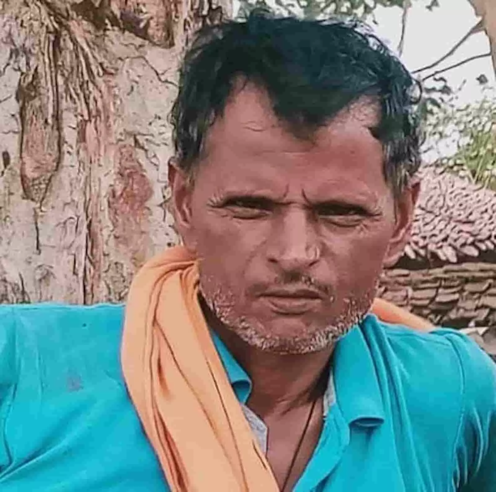 नीली शर्ट पहने एक अधेड़ उम्र के व्यक्ति की तस्वीर। नीली शर्ट पहने एक अधेड़ उम्र के व्यक्ति की तस्वीर।