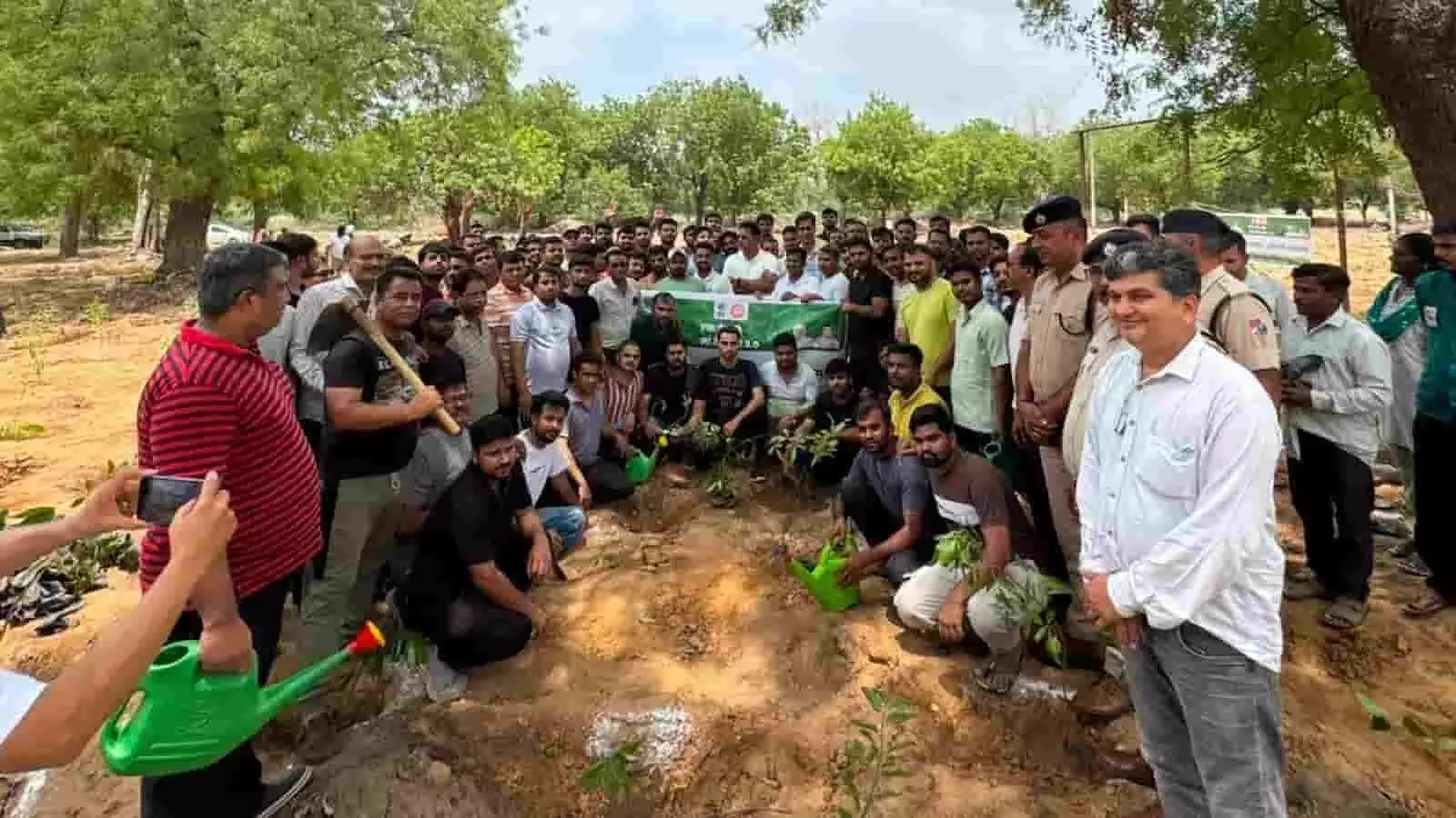 रेलवे अधिकारी और कर्मचारी अहमदाबाद में एक खुले मैदान में पौधारोपण कर रहे हैं।