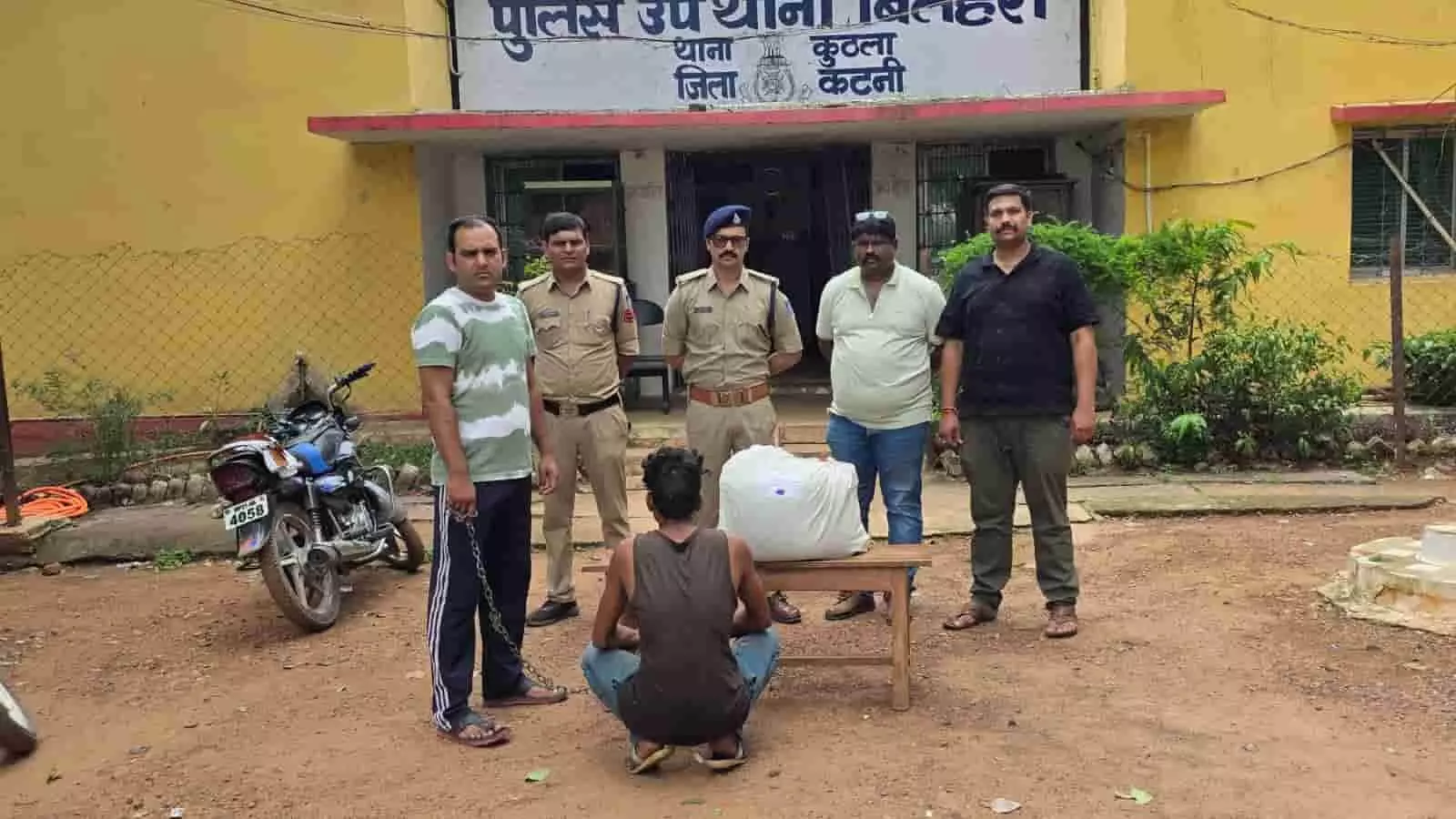 बिलहरी पुलिस थाने के सामने पुलिस टीम और गांजे के साथ बैठा आरोपी।