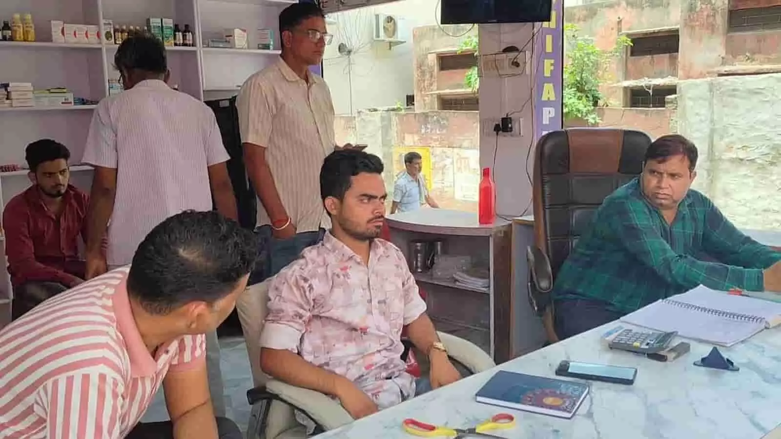 शिफा फार्मेसी एंड क्लिनिक में स्वास्थ्य शिविर के दौरान डॉक्टर और मरीज मौजूद हैं। शिफा फार्मेसी एंड क्लिनिक में स्वास्थ्य शिविर के दौरान डॉक्टर और मरीज मौजूद हैं।