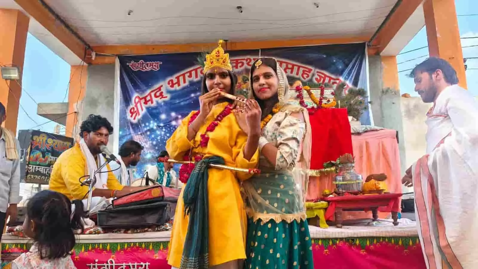 मंच पर वेशभूषा में कलाकार और संगीतकार भागवत कथा के आयोजन में दिख रहे हैं। मंच पर वेशभूषा में कलाकार और संगीतकार भागवत कथा के आयोजन में दिख रहे हैं।