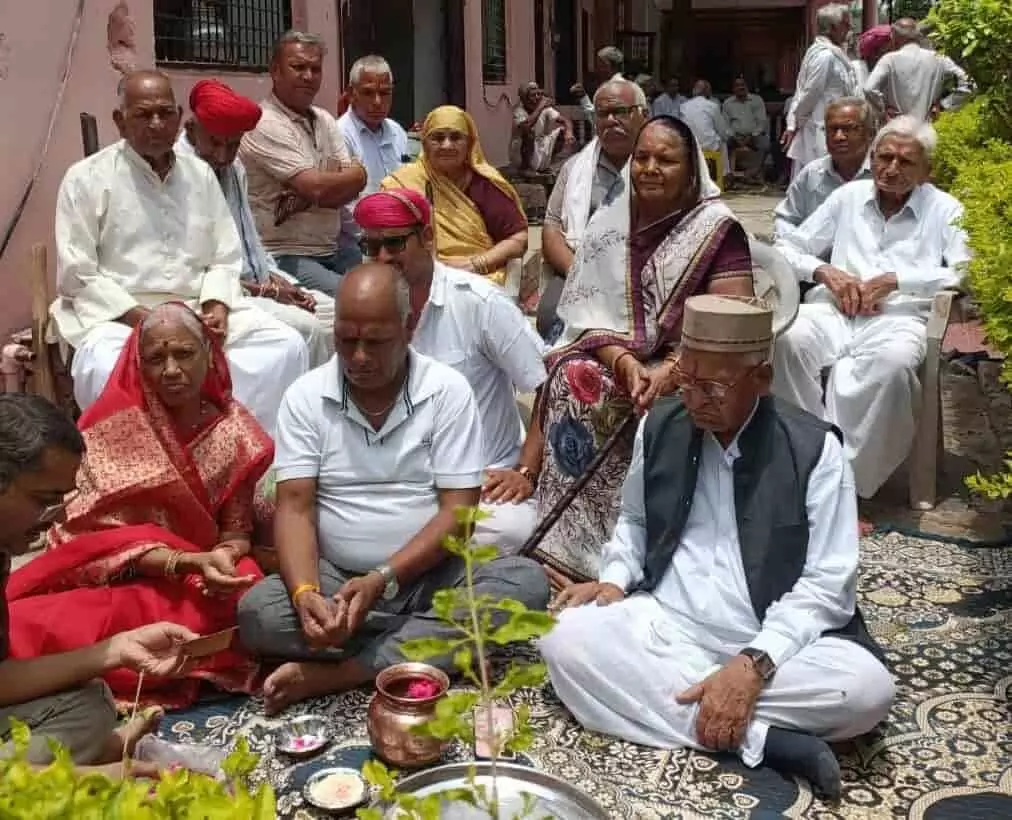 आसावरा माता मंदिर में बद्रीलाल मालू और श्रद्धालु धार्मिक अनुष्ठान के दौरान बैठे हुए हैं।
