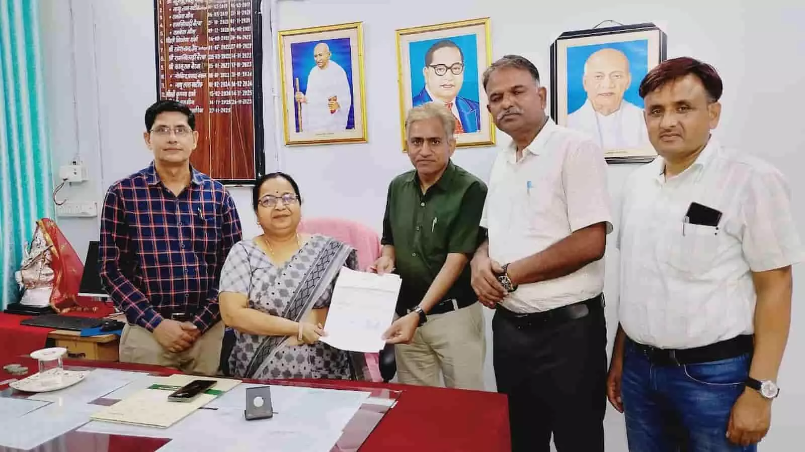 तस्वीर में अधिकारी एक साथ खड़े होकर आधिकारिक दस्तावेज का आदान-प्रदान कर रहे हैं। तस्वीर में अधिकारी एक साथ खड़े होकर आधिकारिक दस्तावेज का आदान-प्रदान कर रहे हैं।