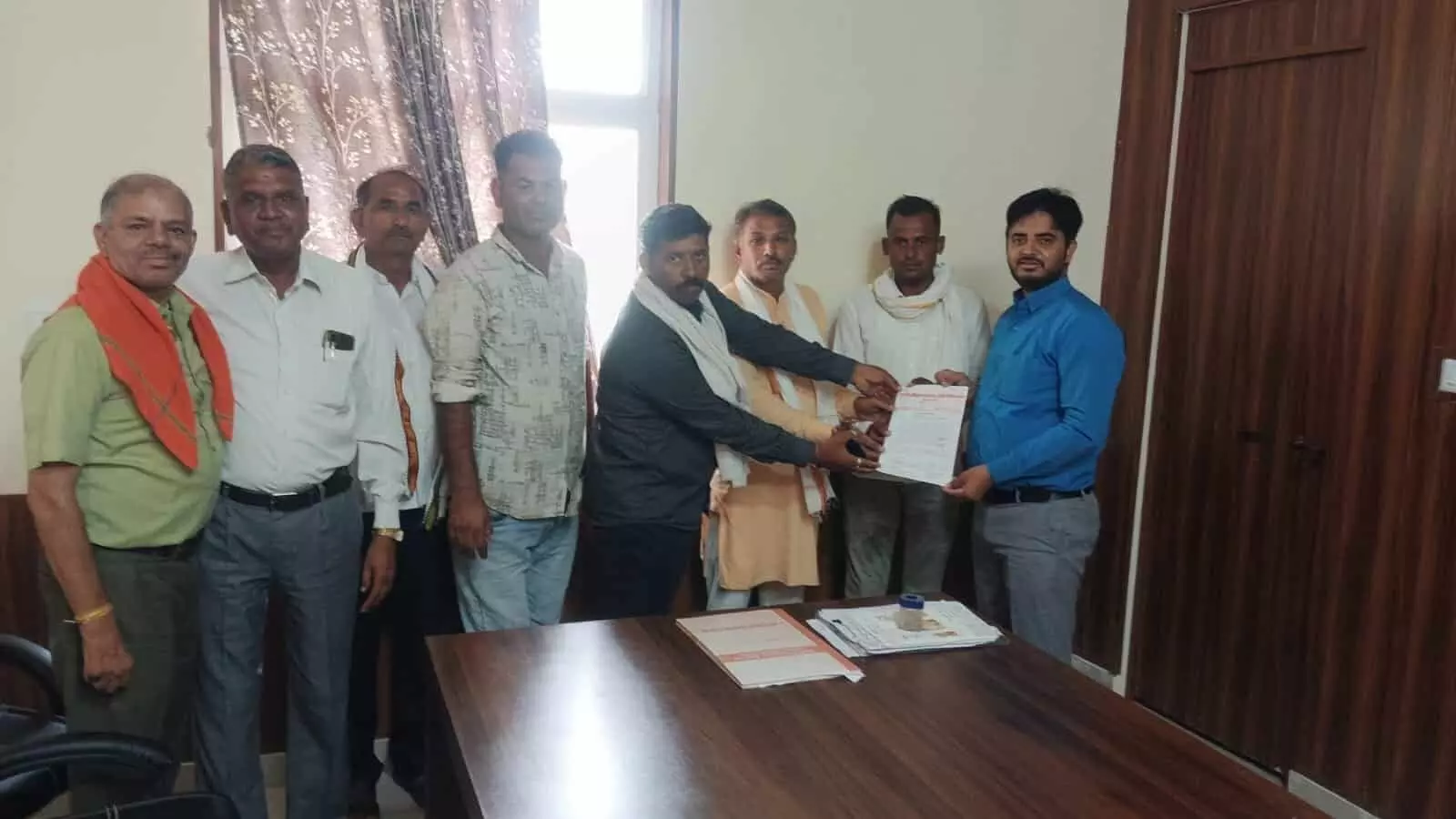 कार्यालय में कुछ व्यक्ति एक अधिकारी को कागज का ज्ञापन सौंपते हुए। कार्यालय में कुछ व्यक्ति एक अधिकारी को कागज का ज्ञापन सौंपते हुए।