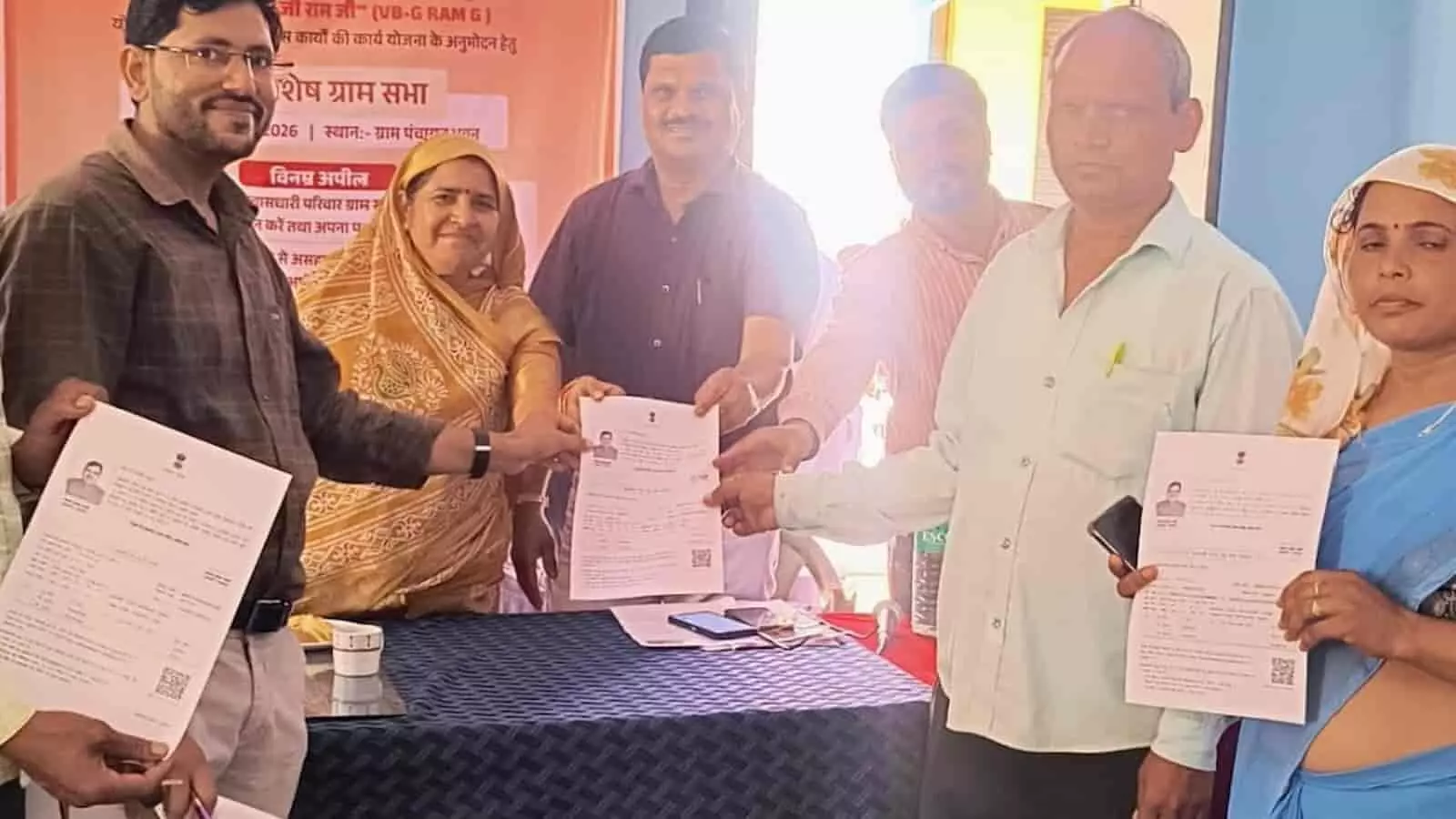 खेरवाड़ा के गुड़ा में आयोजित शिविर में अधिकारी ग्रामीणों को दस्तावेज प्रदान कर रहे हैं।