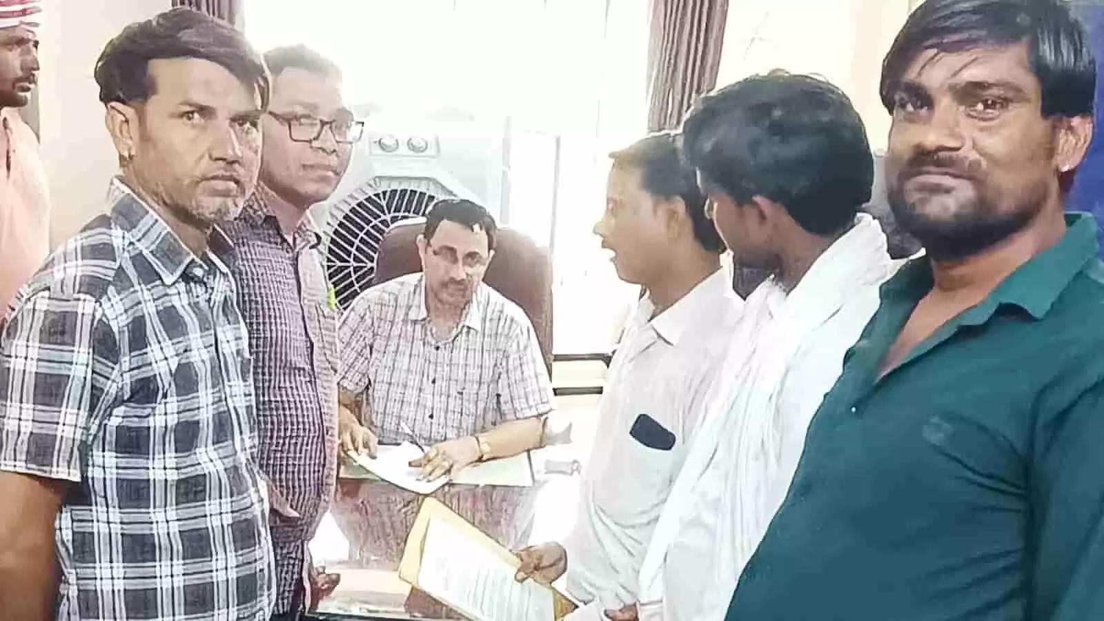 कार्यालय में अधिकारी को ज्ञापन सौंपते हुए ग्रामीण और स्थानीय निवासी दिख रहे हैं।