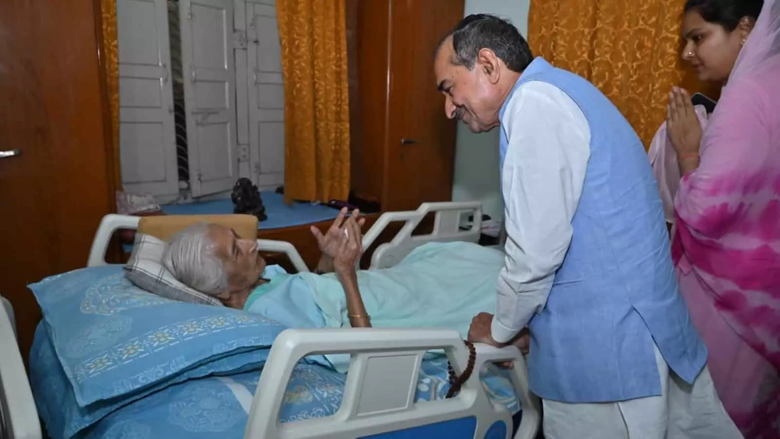 मदन राठौड़ अस्पताल के बिस्तर पर लेटी सुमित्रा सिंह से बातचीत कर रहे हैं।