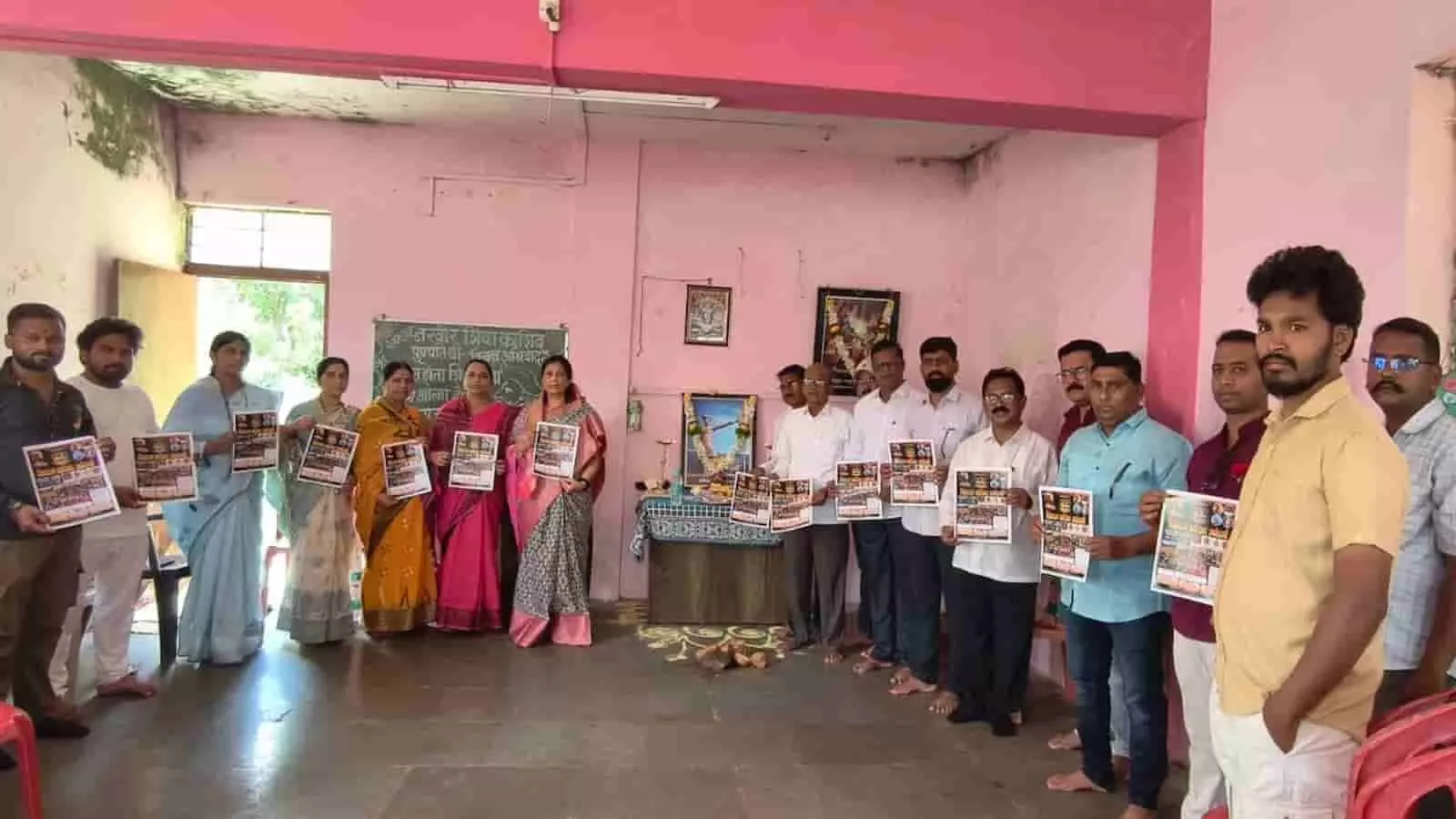 कोल्हापुर में एक इनडोर बैठक में अपने हाथों में कागज लिए खड़े लोग। कोल्हापुर में एक इनडोर बैठक में अपने हाथों में कागज लिए खड़े लोग।