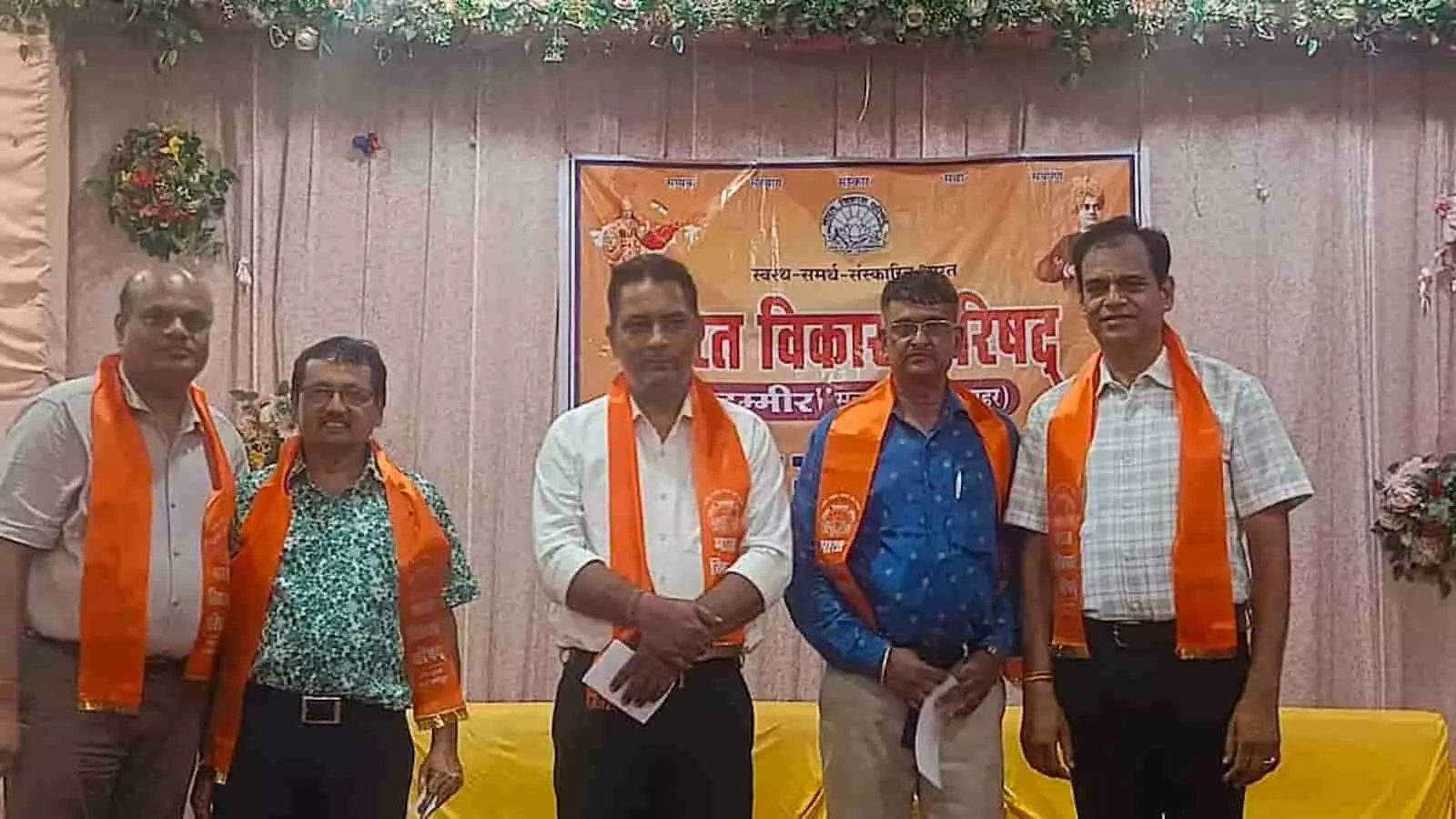 तस्वीर में भारत विकास परिषद कार्यक्रम के मंच पर नवनिर्वाचित पदाधिकारी भगवा दुपट्टा पहने खड़े दिख रहे हैं।
