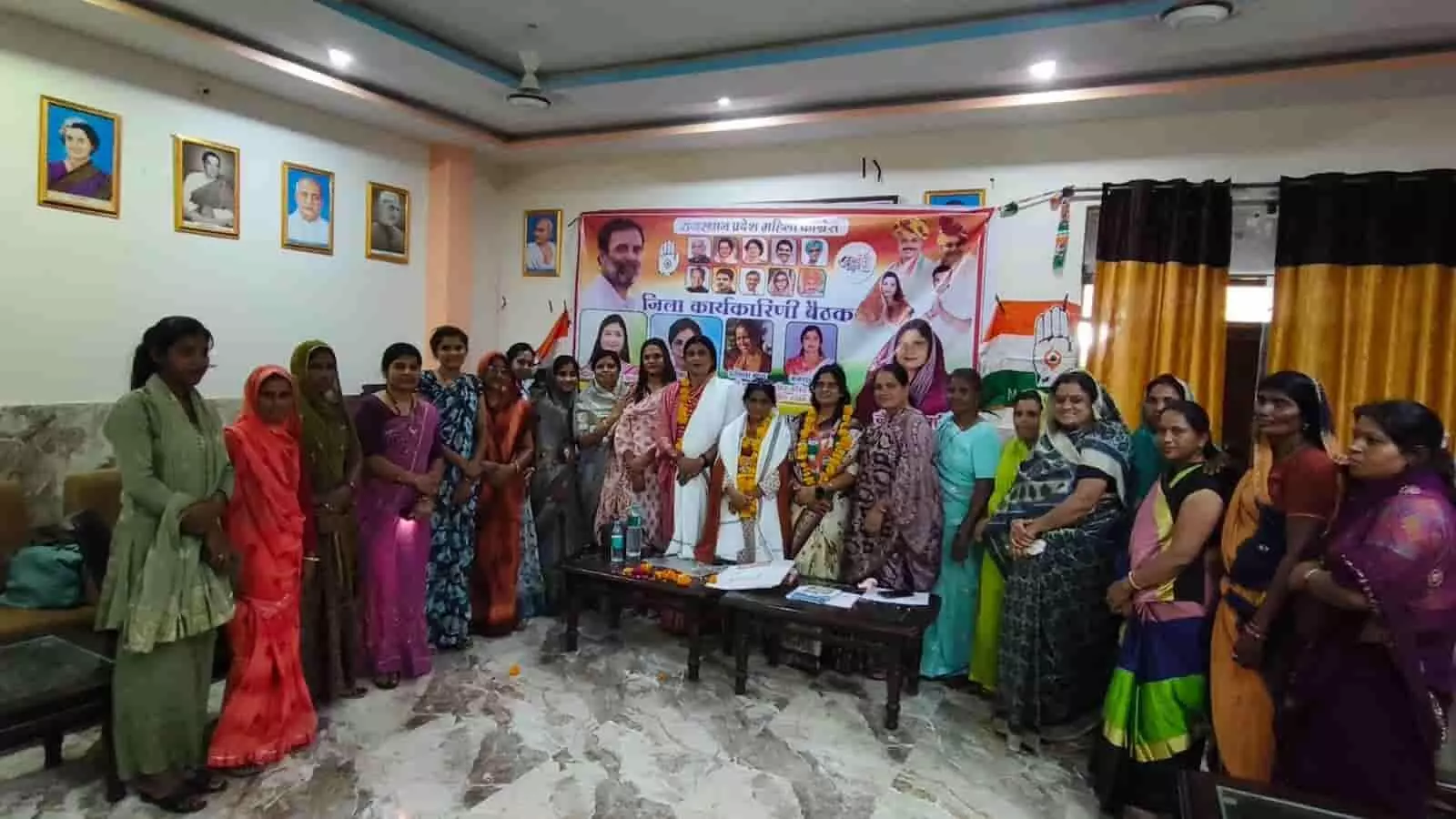 कांग्रेस कार्यालय में बैनर के सामने खड़ी महिला कांग्रेस पदाधिकारी और कार्यकर्ता बैठक के दौरान। कांग्रेस कार्यालय में बैनर के सामने खड़ी महिला कांग्रेस पदाधिकारी और कार्यकर्ता बैठक के दौरान।
