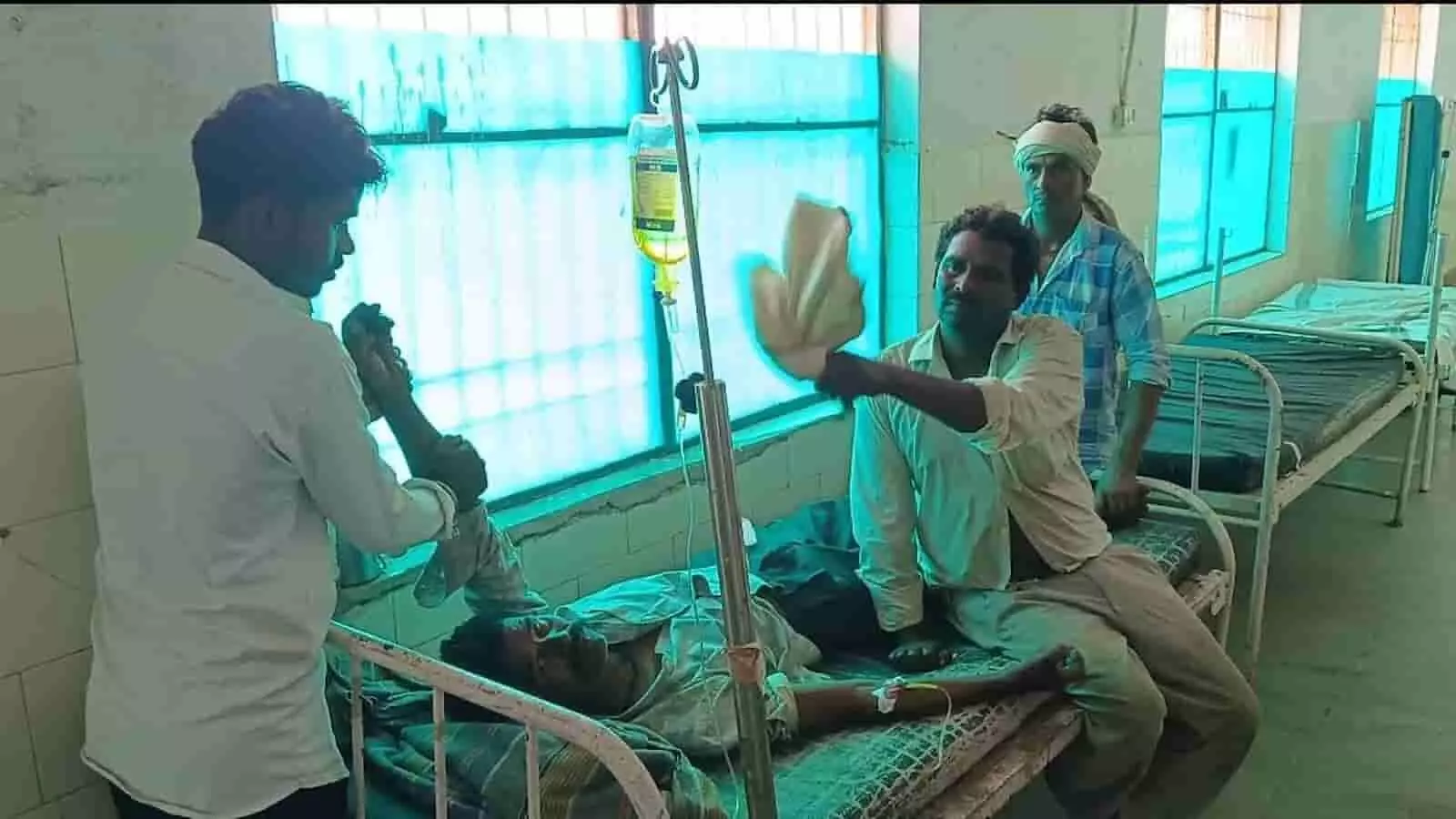 अस्पताल के वार्ड में बेड पर उपचाराधीन मरीज और उनकी देखरेख करते लोग। अस्पताल के वार्ड में बेड पर उपचाराधीन मरीज और उनकी देखरेख करते लोग।