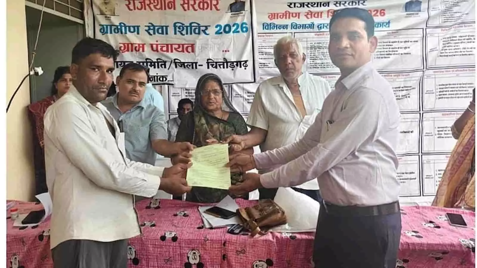 ग्रामीण सेवा शिविर में अधिकारी ग्रामीण को सरकारी दस्तावेज सौंपते हुए दिख रहे हैं। ग्रामीण सेवा शिविर में अधिकारी ग्रामीण को सरकारी दस्तावेज सौंपते हुए दिख रहे हैं।