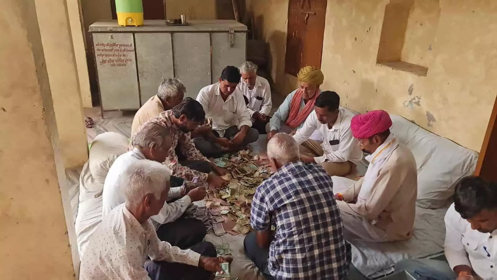 मंदिर के ट्रस्टी जमीन पर बैठकर दान पात्र से निकली राशि गिन रहे हैं। मंदिर के ट्रस्टी जमीन पर बैठकर दान पात्र से निकली राशि गिन रहे हैं।