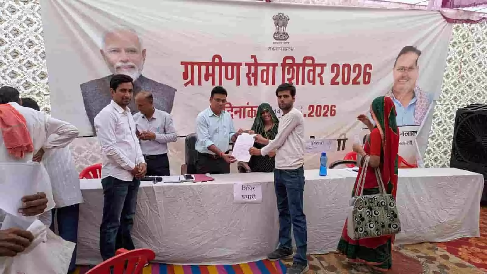 ईंटाली के ग्रामीण सेवा शिविर में अधिकारी द्वारा एक नागरिक को आवासीय पट्टा सौंपने का दृश्य। ईंटाली के ग्रामीण सेवा शिविर में अधिकारी द्वारा एक नागरिक को आवासीय पट्टा सौंपने का दृश्य।